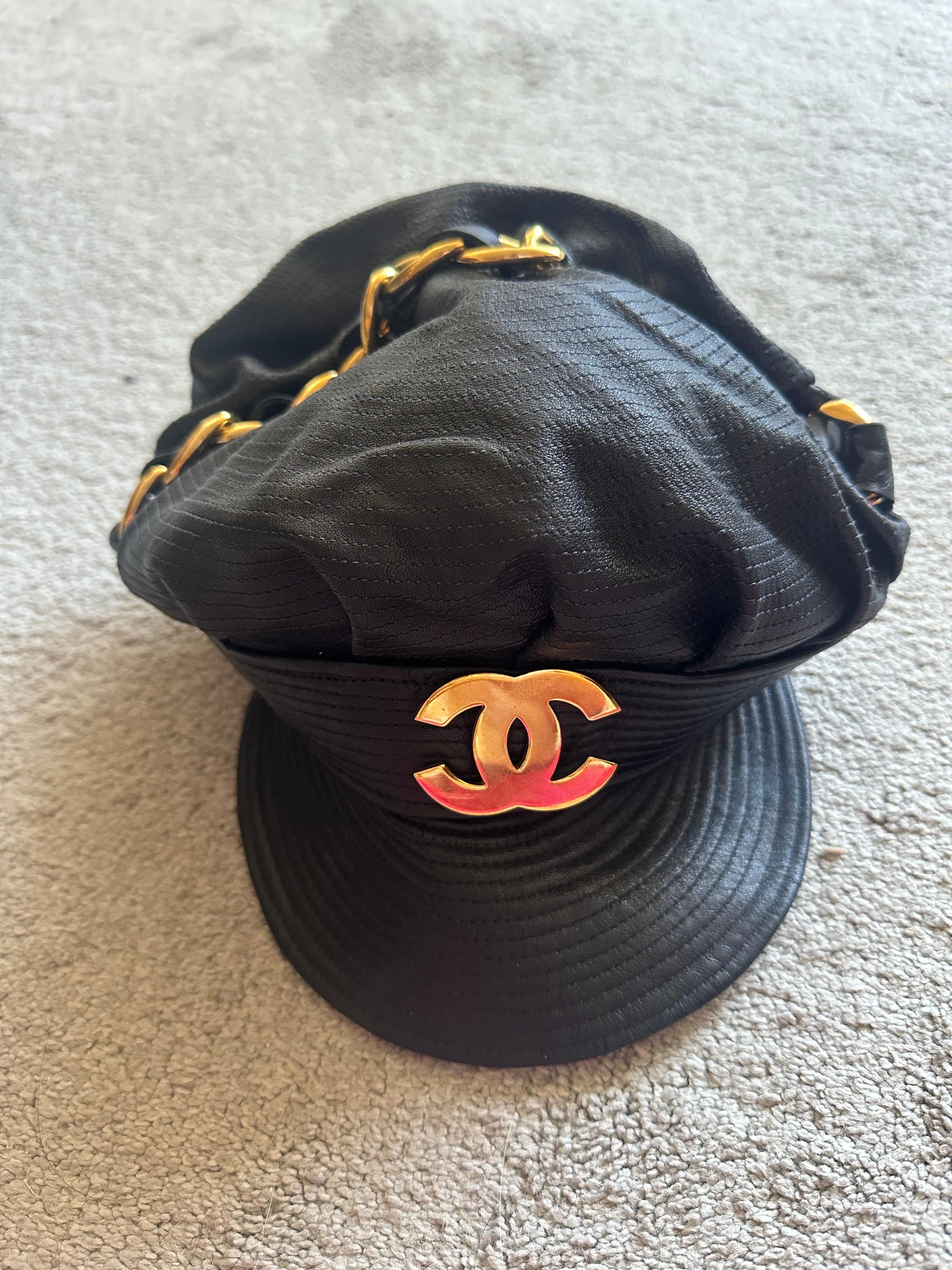 Chanel Fall 1991 Iconic Leather Chain Biker Hat

Iconic leather biker hat in black adorned with gold Chanel logo hardware from the fall 1991 collection designed by Karl Lagerfeld for Chanel. Size 57 (Fits like a size small)

Good overall condition -