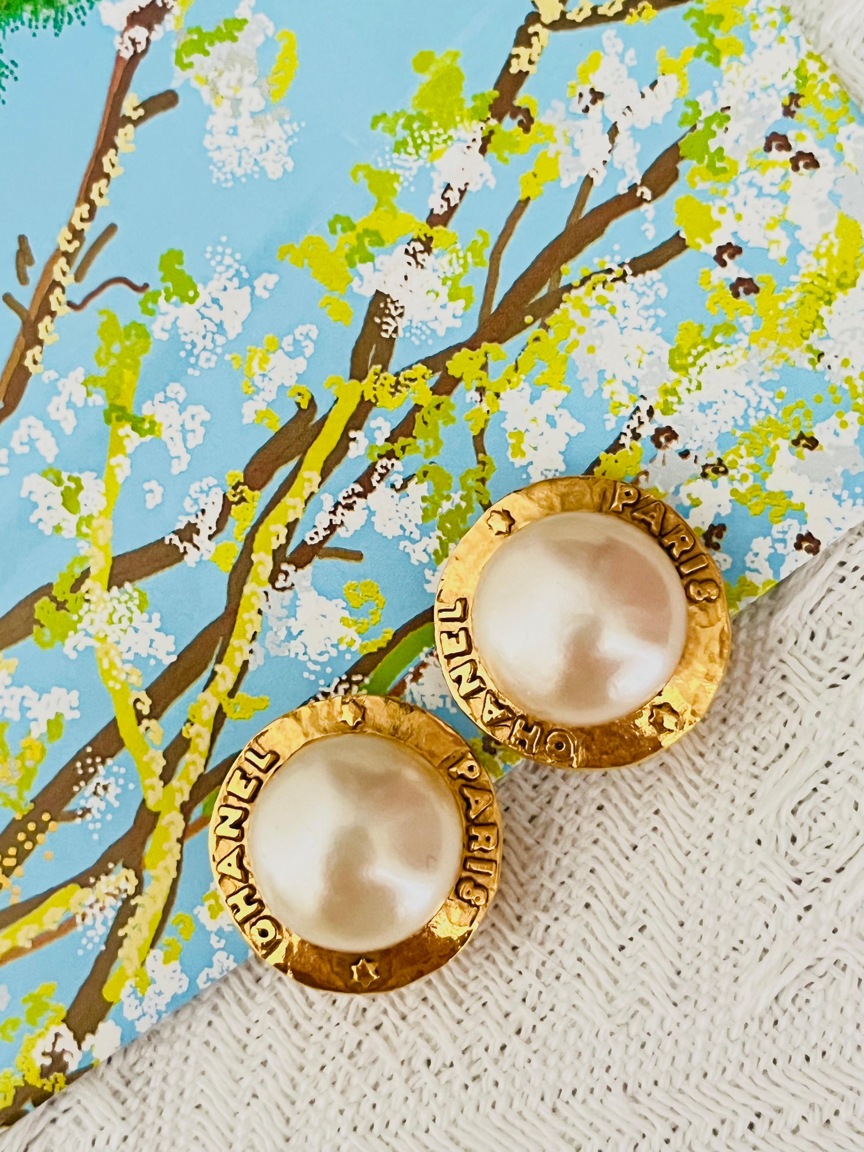 Chanel Vintage 1991 Große Weiße Perle Logo Paris CC Kreis Runde Clip Relief Elegante Clip-Ohrringe, vergoldet

Sehr guter Zustand. 100% echt. Sehr guter Preis.

Ein sehr schönes Paar Ohrringe von CHANEL, auf der Rückseite signiert. 

MATERIAL: