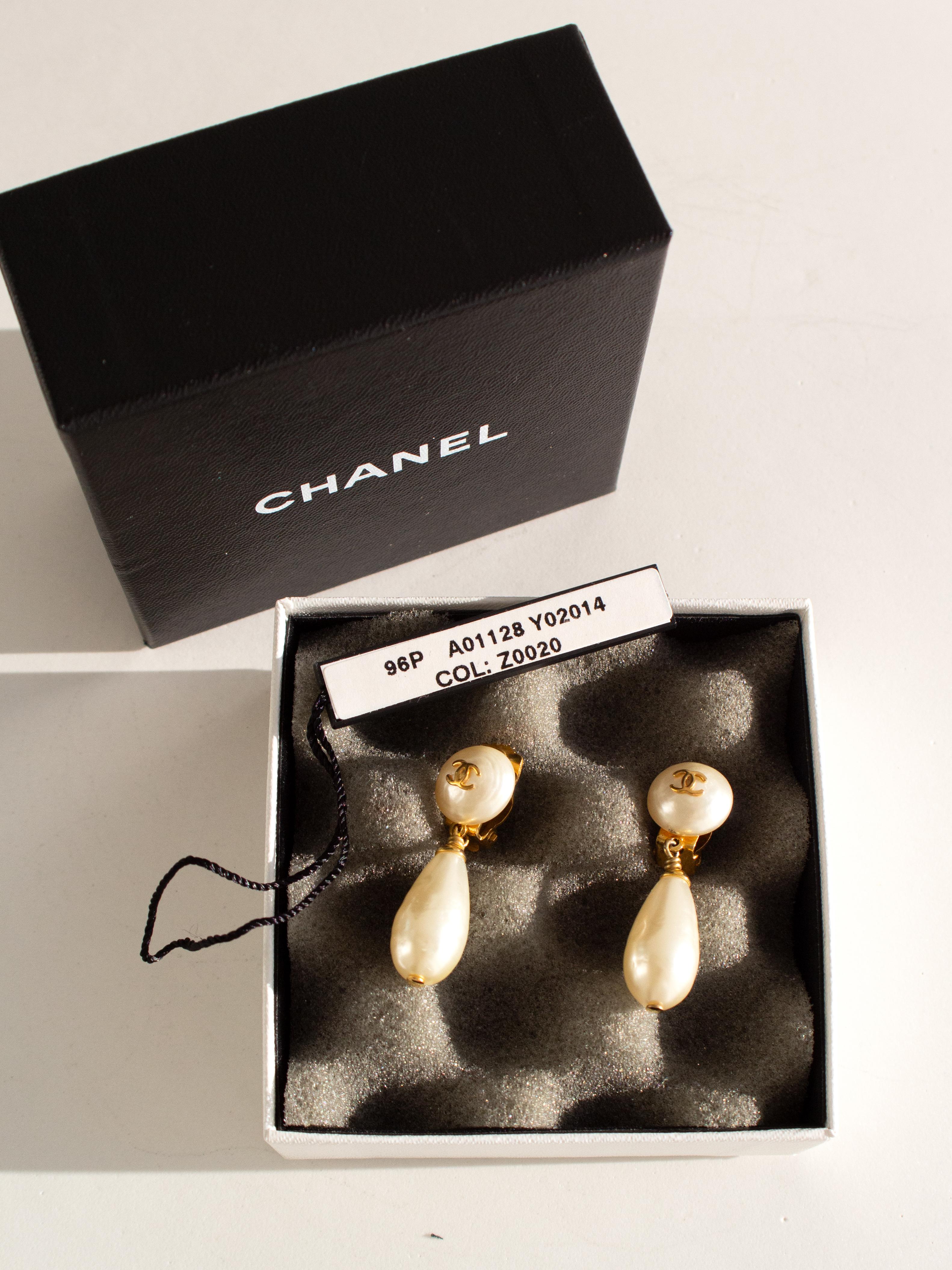 These exquisite Chanel 96P pearl drop clip earrings are a classic piece from Chanel's 1996 Spring collection. The earrings feature a timeless design with faux pearl buttons accented by the iconic gold-tone CC logo, paired with elegant