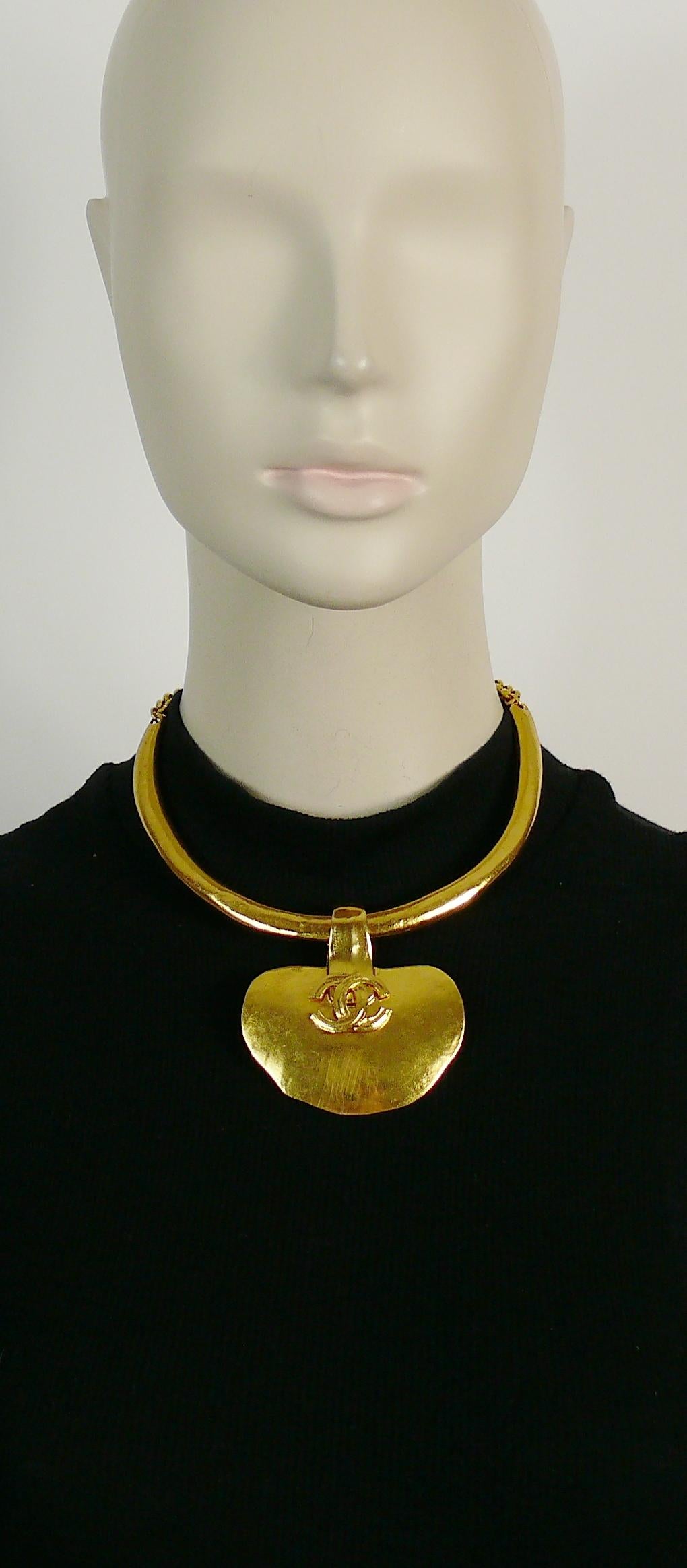 CHANEL vintage rare 1998 gold toned textured torque necklace featuring a large irregular shaped pendant with CC logo at center.

Hook clasp closure.
Extension chain with CC charm.

Spring/Summer 1998 Collection.

Marked CHANEL 98 P MADE IN