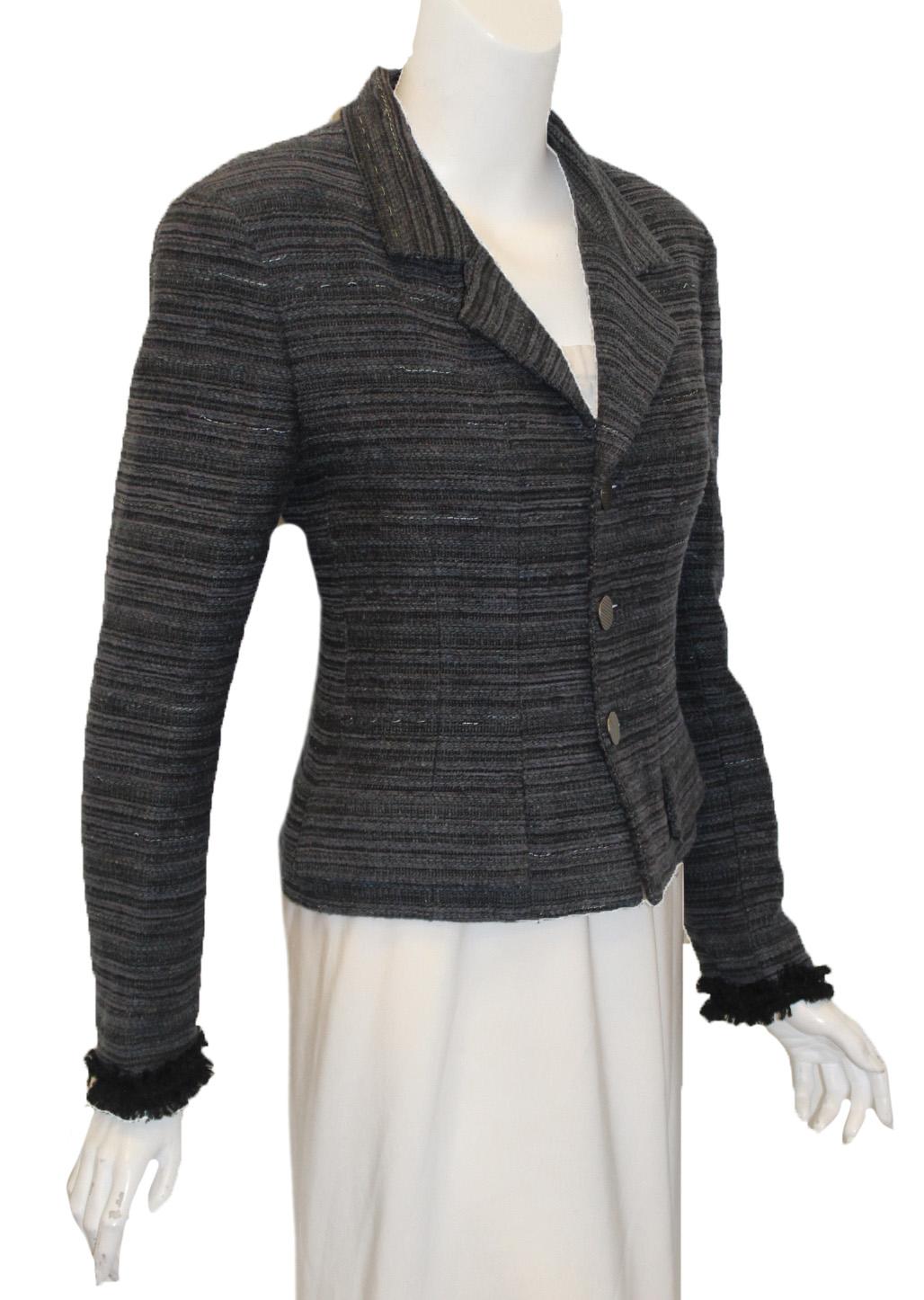 Chanel vintage blue and grey tweed wool blend  jacket from the fall 1999 collection incorporates 3 silver tone Chanel buttons for closure at front.  This jacket with notch collar and long sleeves with fringe on cuffs is constant with the vintage