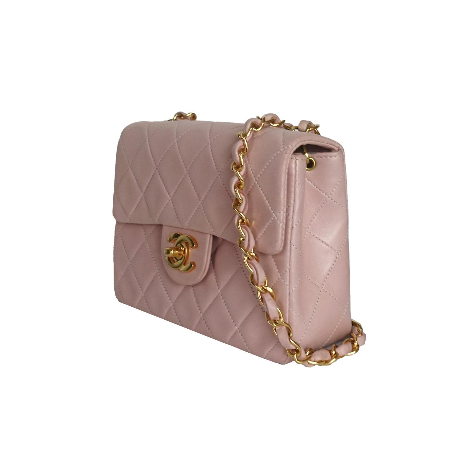 Crafted in the late '90s, this Chanel Vintage 1999 Pink Mini Square Classic Flap Bag features soft pink quilted lambskin and gold-toned hardware for timeless elegance. The iconic CC turn-lock opens to a compact interior with a zip pocket, slip
