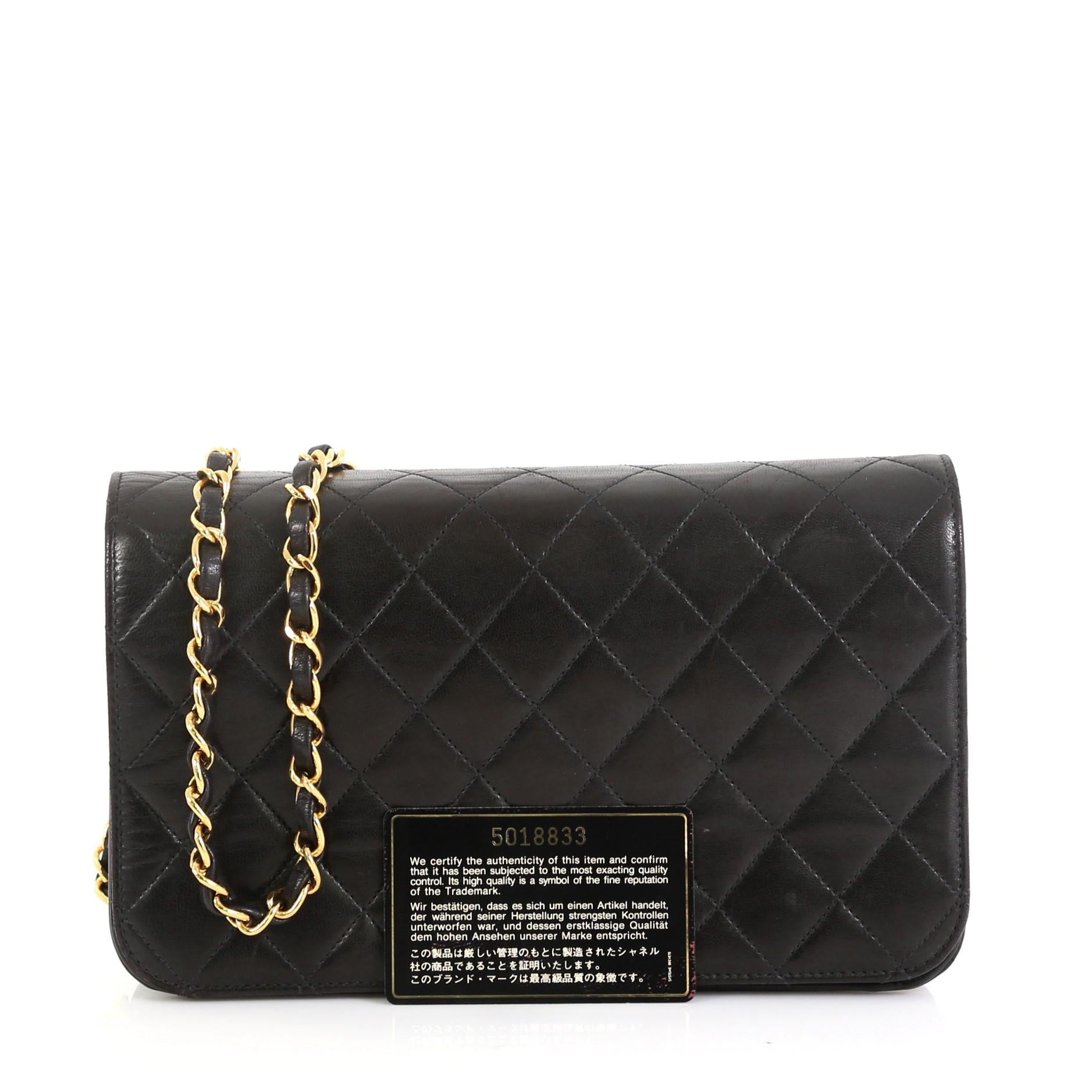 This Chanel Vintage 3 Way Full Flap Bag Quilted Lambskin Small, crafted in black quilted lambskin leather, features woven-in leather chain strap and gold-tone hardware. Its CC turn-lock closure opens to a red leather interior with zip pocket.