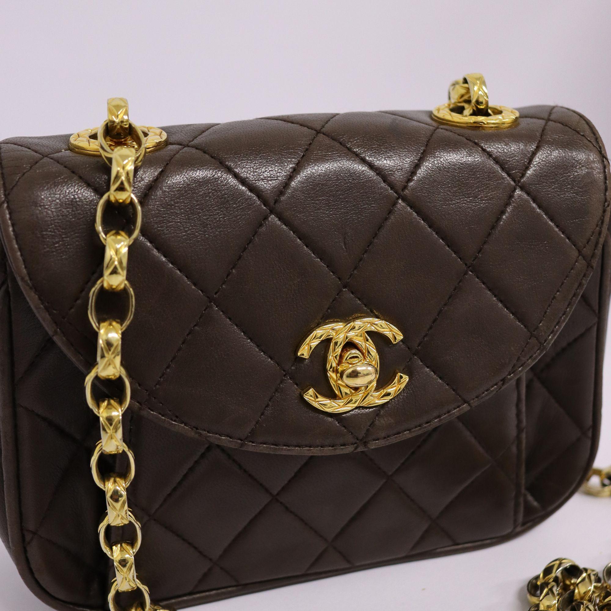 Chanel 90s vintage chocolate brown with classic diamond quilted lambskin. Features chain link shoulder strap and textured CC turn lock. Great condition with minor discoloration on edges. Interior features the same color with a front pocket and one