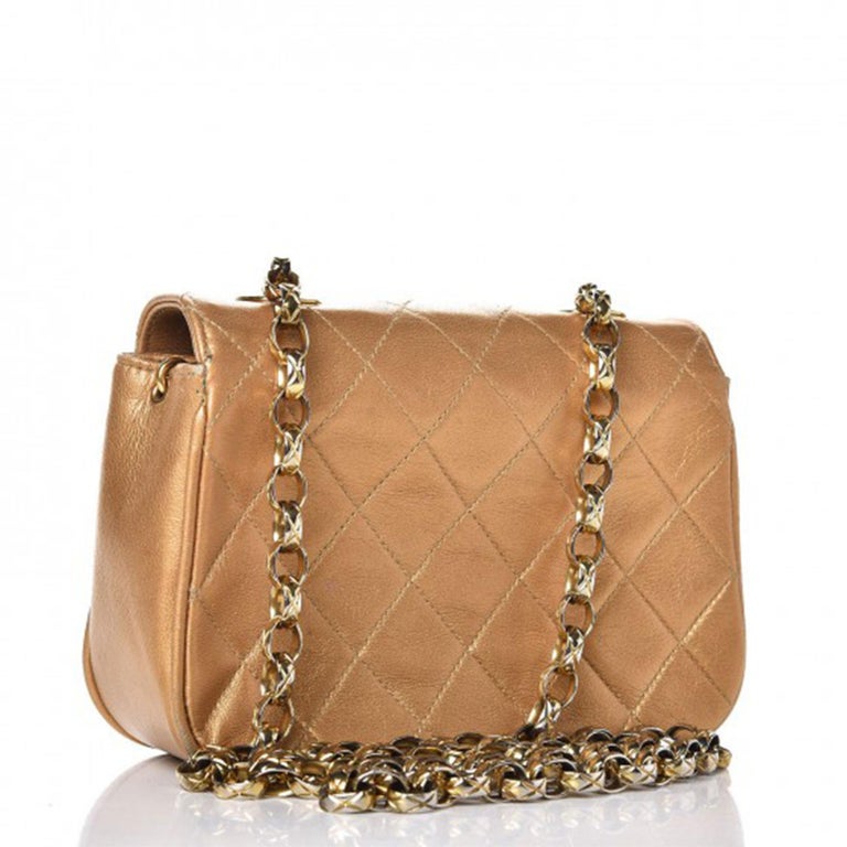 Chanel Vintage 90's Metallic Lambskin Mini Quilted Flap Gold Cross Body Bag
This chic classic model, circa 1991-1994, is finely composed of luxuriously supple diamond quilted lambskin leather in metallic gold. The bag features a gold chain link