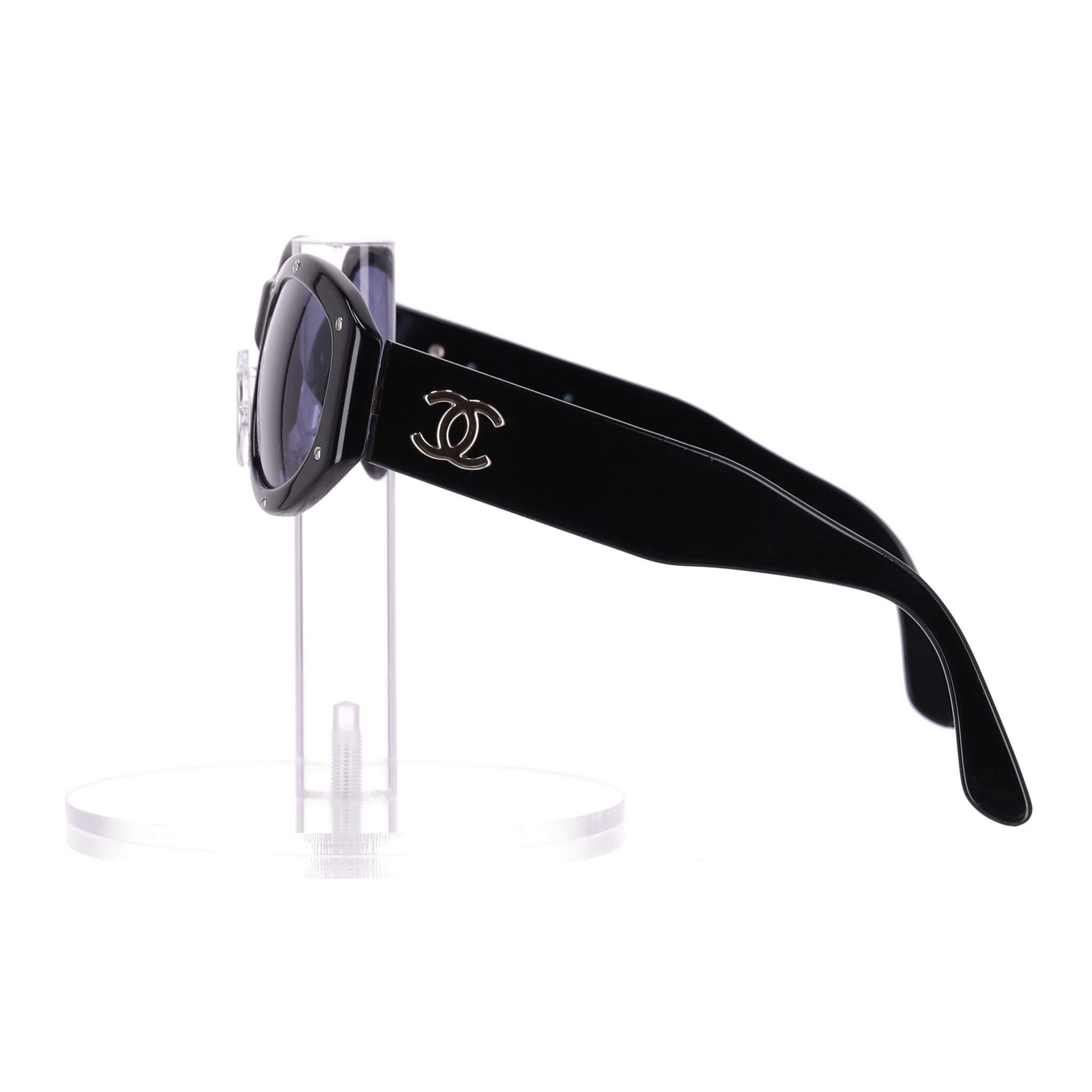 Pièce rare - Lunettes de soleil Chanel Vintage 90's Cat-Eye Stud Detail

Lunettes de soleil noires au design des années 90, exclusives à la boutique, ornées de vis argentées en forme de clous sur le devant.

Le logo iconique 