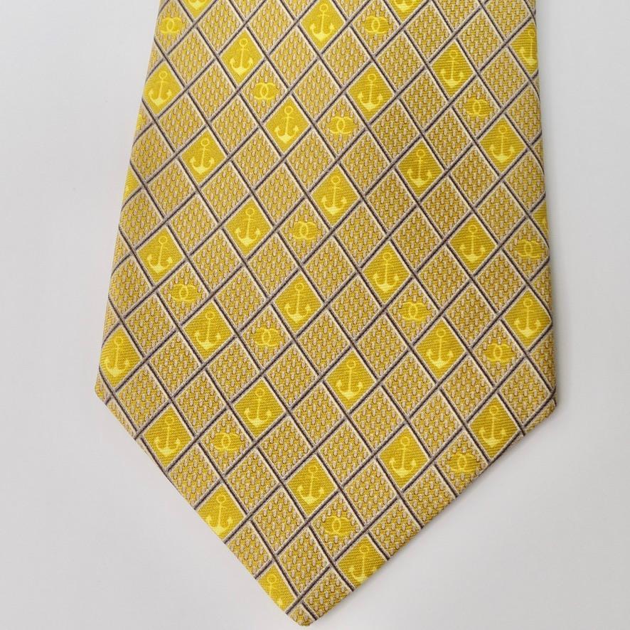 Make waves with this rare nautical Chanel silk tie circa 1980s! All aboard into this super fun nautical Chanel era with this versatile printed tie. A yellow and neutral toned diamond pattern features anchors alongside signature Chanel interlocking