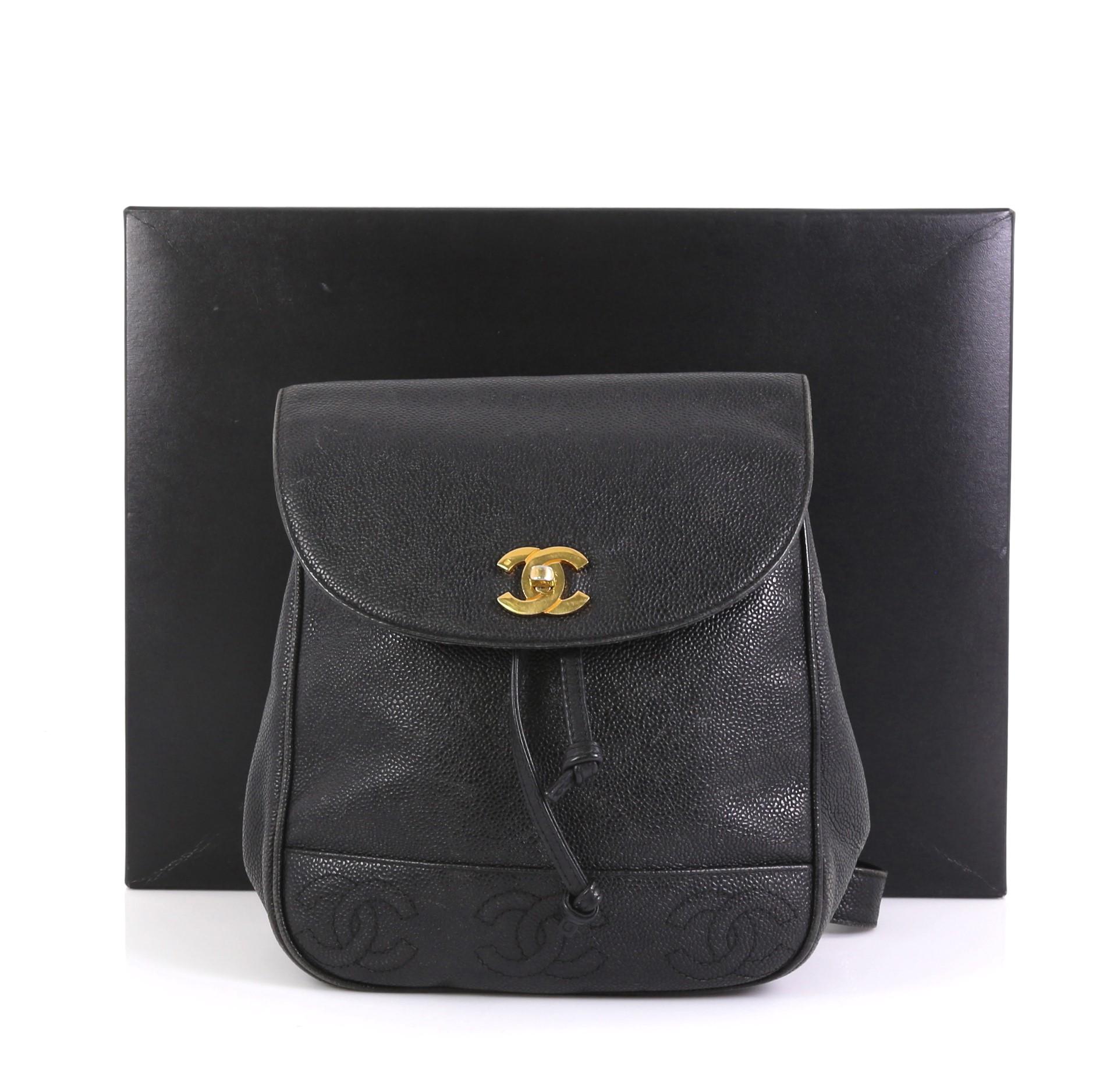 This Chanel Vintage Backpack Caviar Small, crafted from black caviar leather, features CC stitched design at the bottom, leather straps, and gold-tone hardware. Its CC turn-lock and drawstring closure opens to a black fabric interior with zip