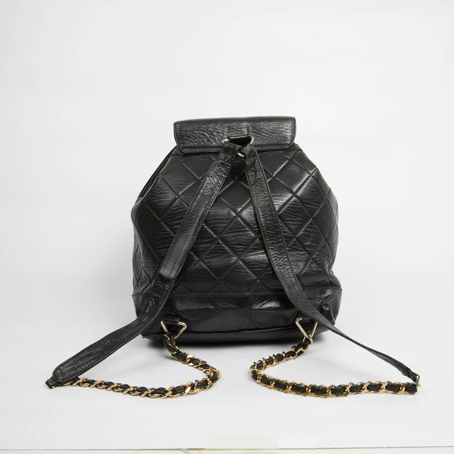 Beautiful vintage CHANEL piece from the early 80s in black calfskin. The jewelry is golden but passed in some places (see photos). Opening by flap which gives on a burgundy lining, a zipped pocket. Closing with a tightening link with two small