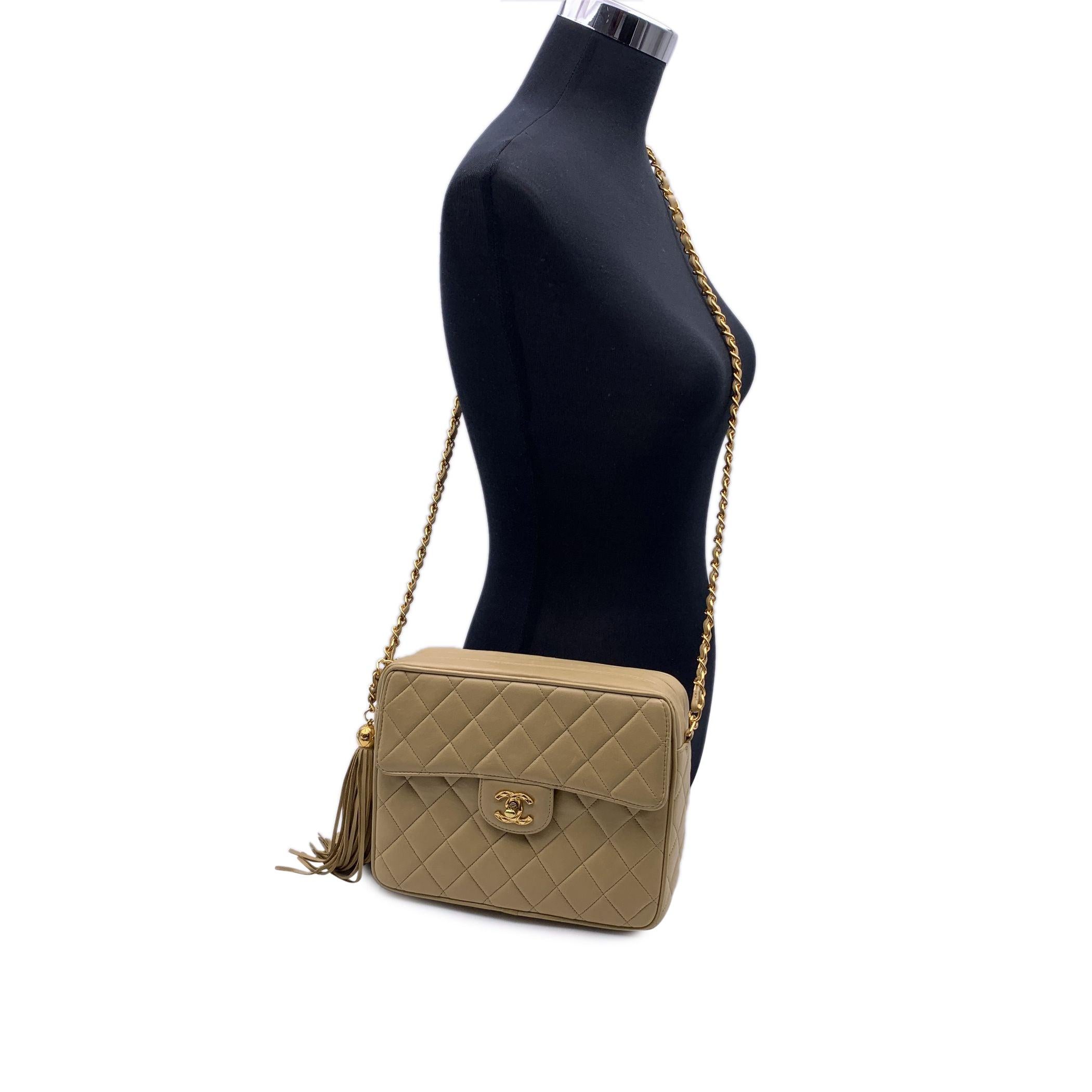 Vintage Chanel Quilted 'Camera Bag' Shoulder Bag in beige color. Period/Era: 1991-1994. Features upper zipper closure, leather tasel zipper pull and 1 front flap pocket with CC turn lock closure. Beige leather lining with 1 side zip pocket and 1