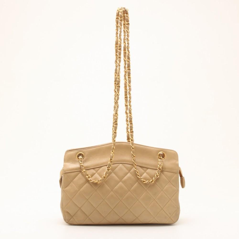 This bag is sure to draw anyone’s attention because of its vintage look. This tote is crafted from leather. The golden chain woven into beige leather strap adds to its charm. Golden monogrammed rivets on the top complement the shoulder string. The