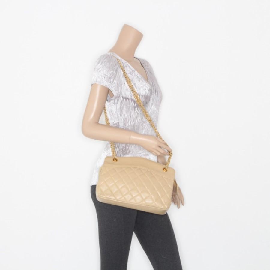 This bag is sure to draw anyone’s attention because of its vintage look. This tote is crafted from leather. The golden chain woven into beige leather strap adds to its charm. Golden monogrammed rivets on the top complement the shoulder string. The