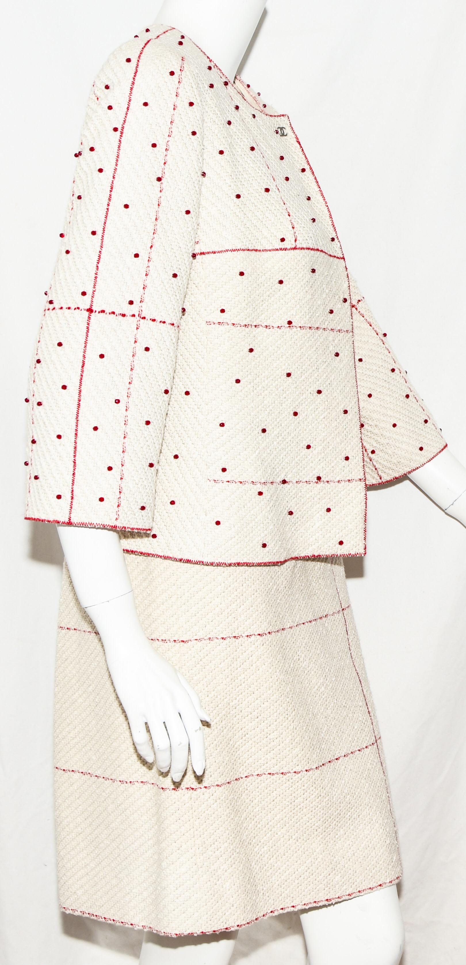 Chanel vintage beige two piece skirt suit encompasses tonal stitching in check pattern on both skirt and jacket is from the 2000 Cruise collection.  Only the jacket has been emphasized with red beads strategically placed all over.  It includes a
