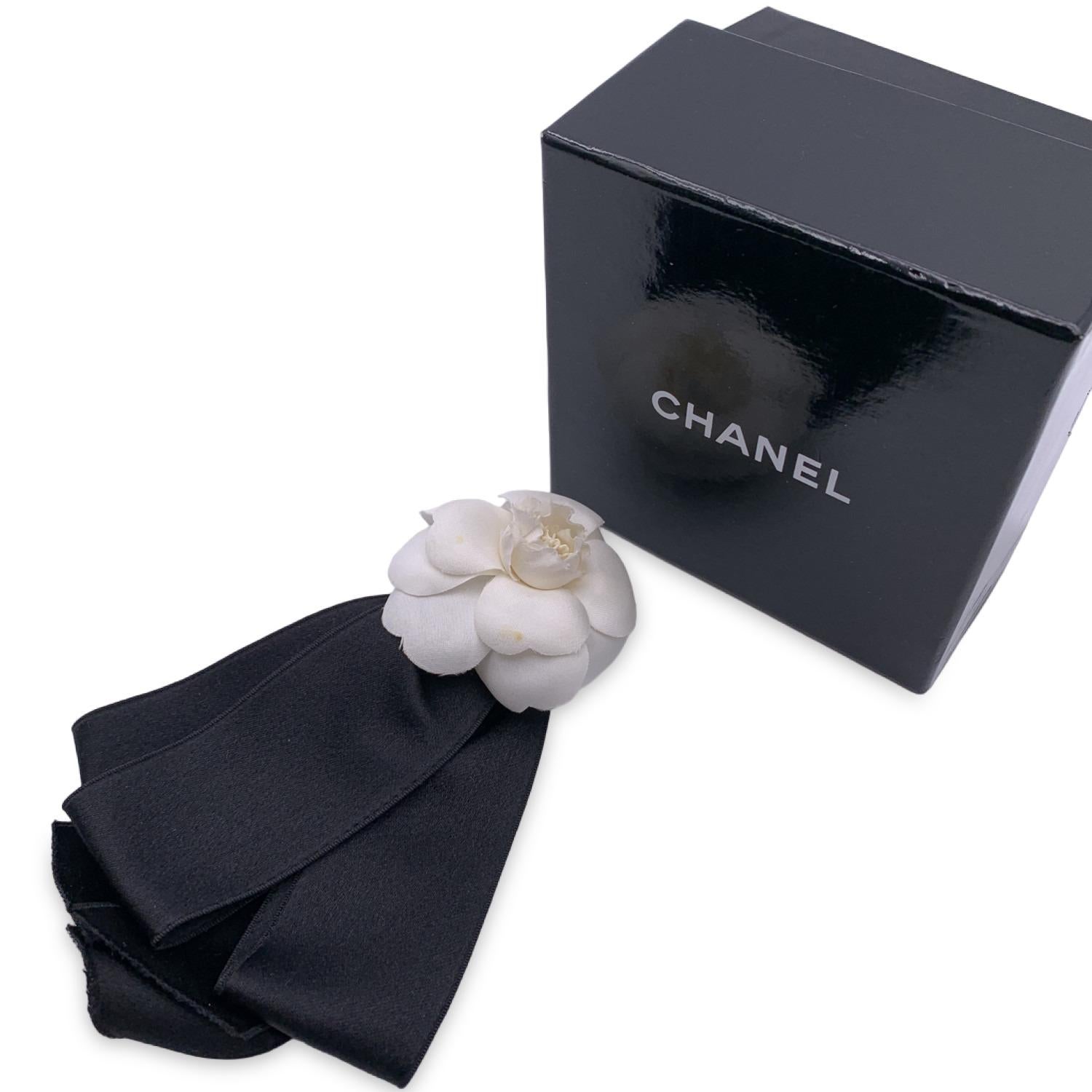 Lovely vintage Chanel brooch. White silk Camellia flower with black silk ribbons.  'Chanel CC Made in France' oval tab on the back. Flower width 2.5 inches - 6.4 cm. Heeight: 6.5 inches - 16.5 cm. Chanel box included.

B - VERY GOOD
A small brown