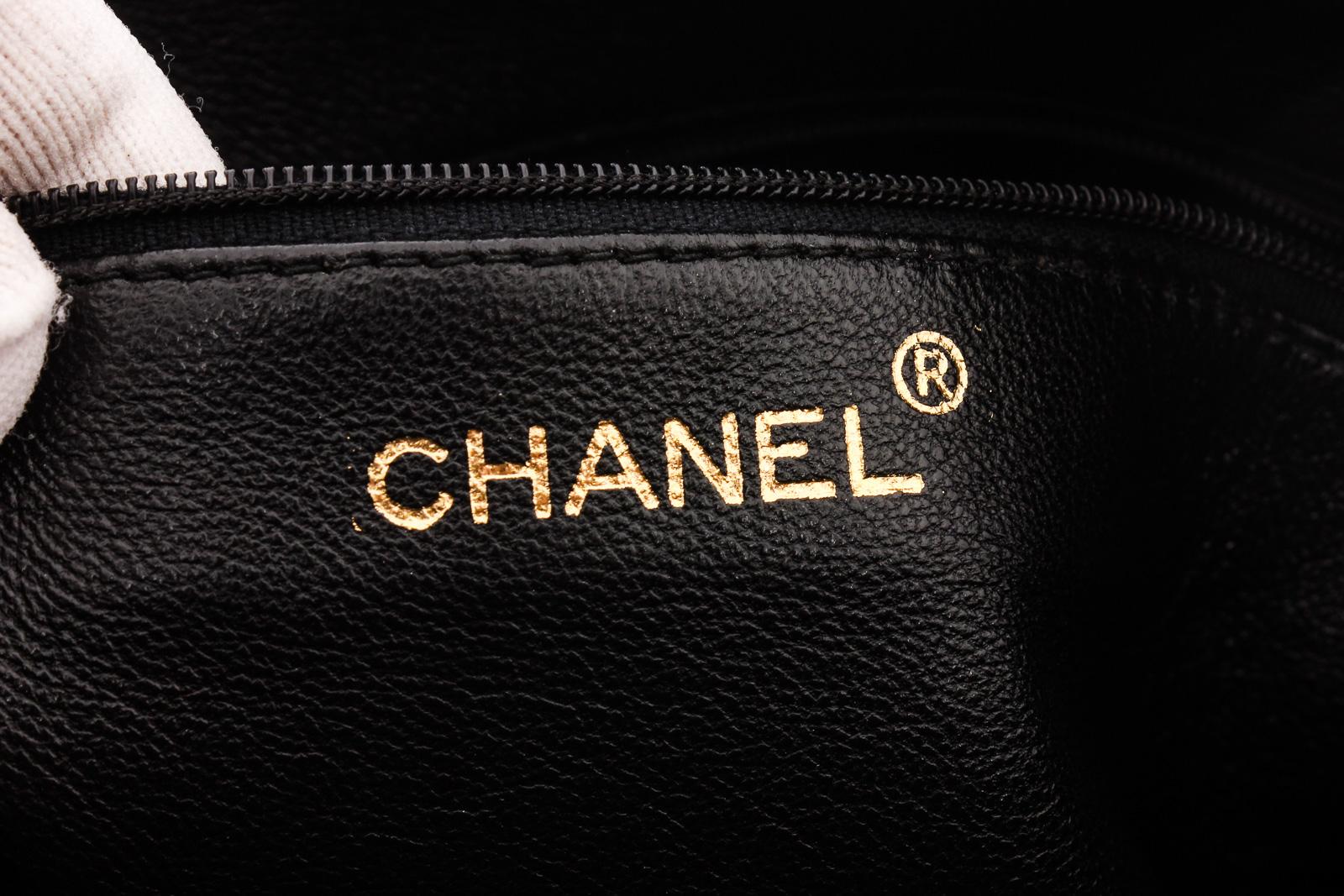 Black quilted calfskin vintage Chanel Camera bag with gold-tone hardware, single chain-link shoulder strap, stitched CC logo at front face, exterior slit pocket, tonal leather lining, single zip pocket at interior wall and tassel embellished zip