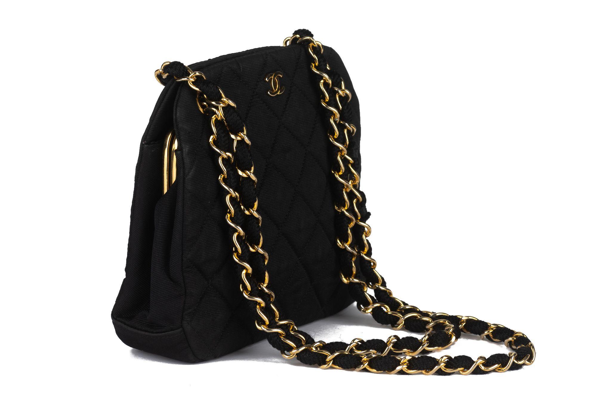 This Chanel Matelasse Chain Shoulder Bag in black toile has gold hardware and a chain link shoulder strap and a classic CC logo on the front. The top is fastened by a clasp that opens up to a roomy interior with two slit pockets. Comes with hologram