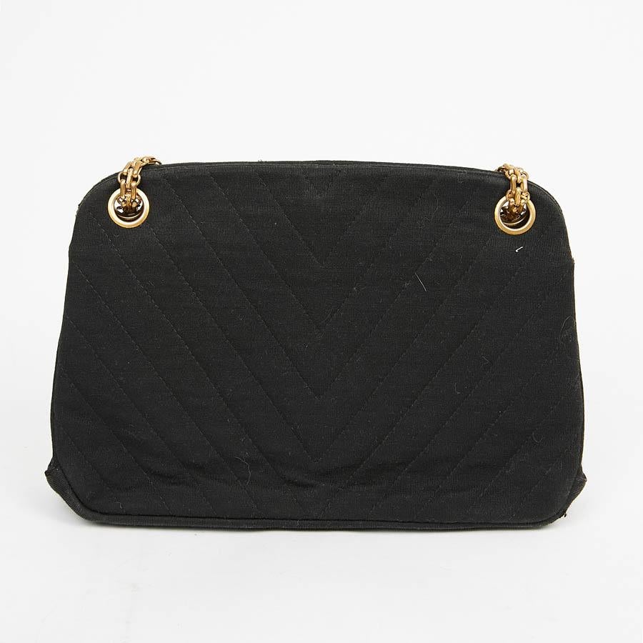 This beautiful little vintage evening bag is in black jersey. The jewelry is in golden metal, its chain can be worn in single or double. The bag has two storage bellows with a zipped pocket on each side separated by a pocket with a wallet clasp.