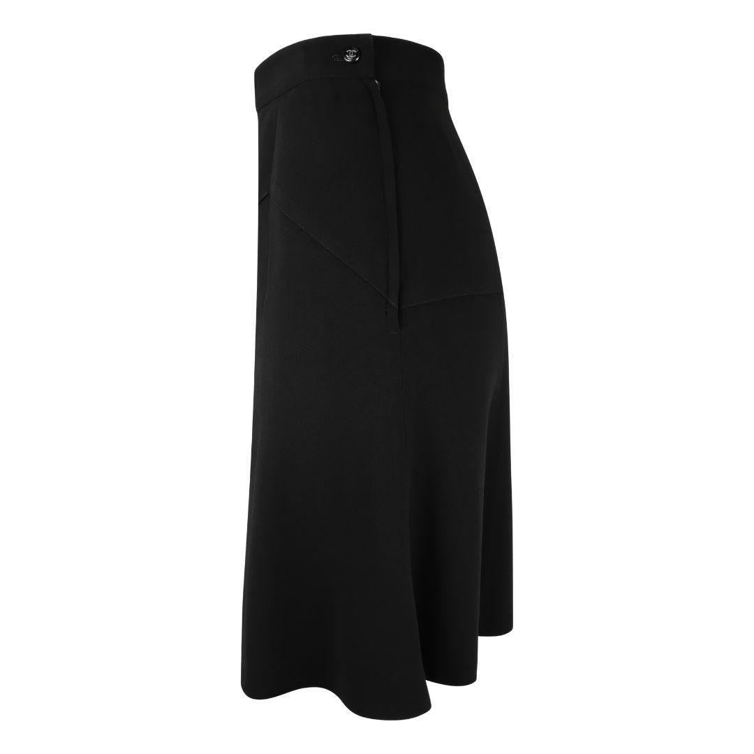Vintage Chanel basic black knee length flared wool skirt with downward zig zag panels angled from the waist at the front.

Flowy, flared silhouette.

Length hits above the knees.

Concealed side zipper.

Exposed interlocking CC logo button at the