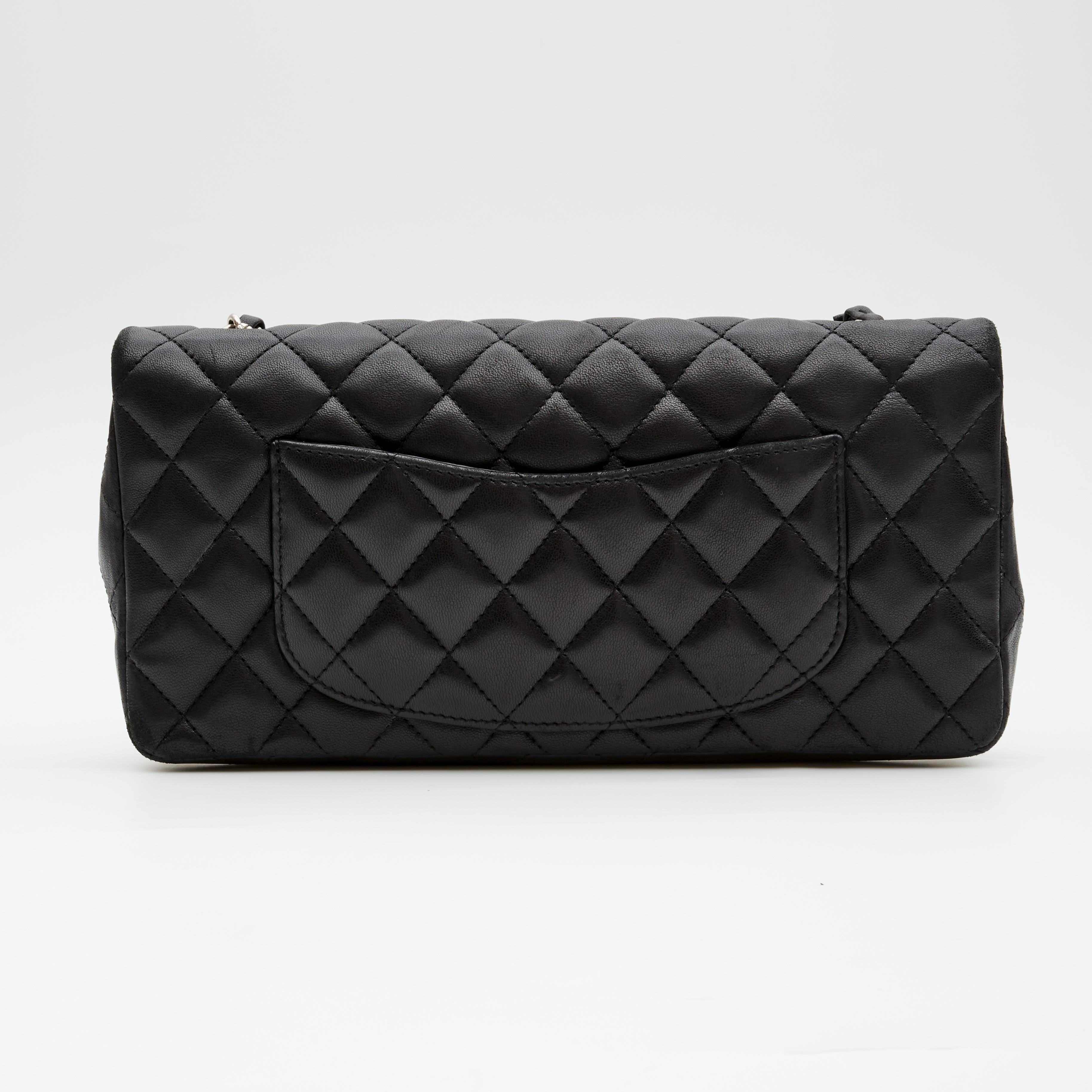 This shoulder bag is made with diamond quilted black lambskin leather. The extra-wide bag features sliver-tone hardware, a front flap with the signature interlocking CC turn lock closure, and a sliver-tone chain interlaced with leather. The front