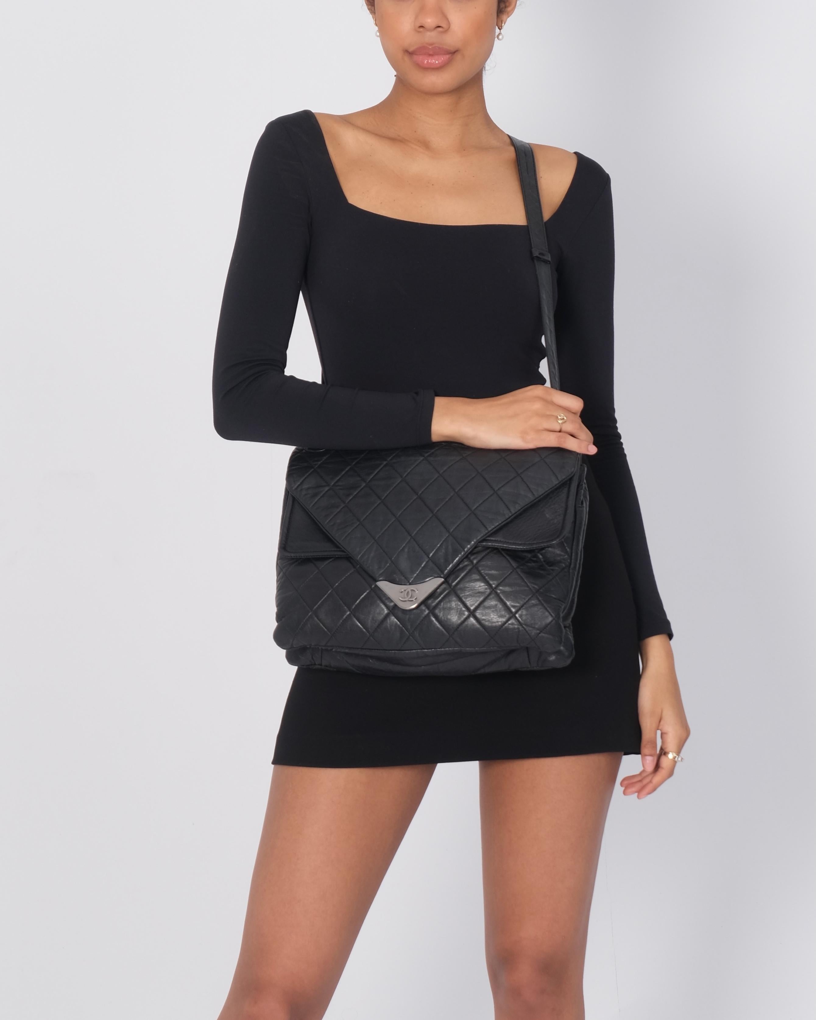 Este bolso está fabricado en piel de cordero cosida a rombos en color negro. La bandolera tiene una correa de piel y herrajes de rutenio. La solapa se abre a un interior de satén gris con un bolsillo con cremallera. Bolsa vintage.

Color: