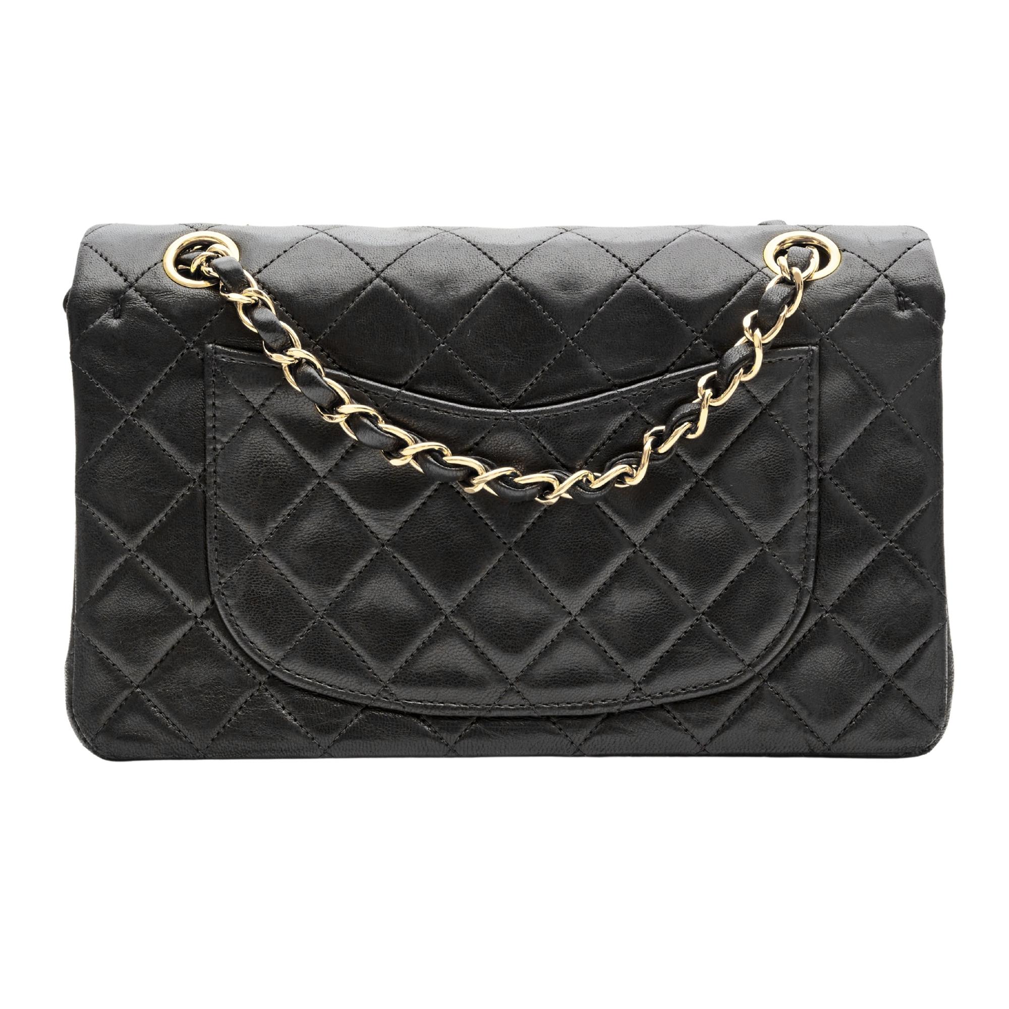 This Chanel bag is made with lambskin leather in black with signature diamond stitching. The bag features gold tone hardware, a front flap with the interlocking CC turn lock closure, a gold toned chain interlaced with leather, a half moon back slip