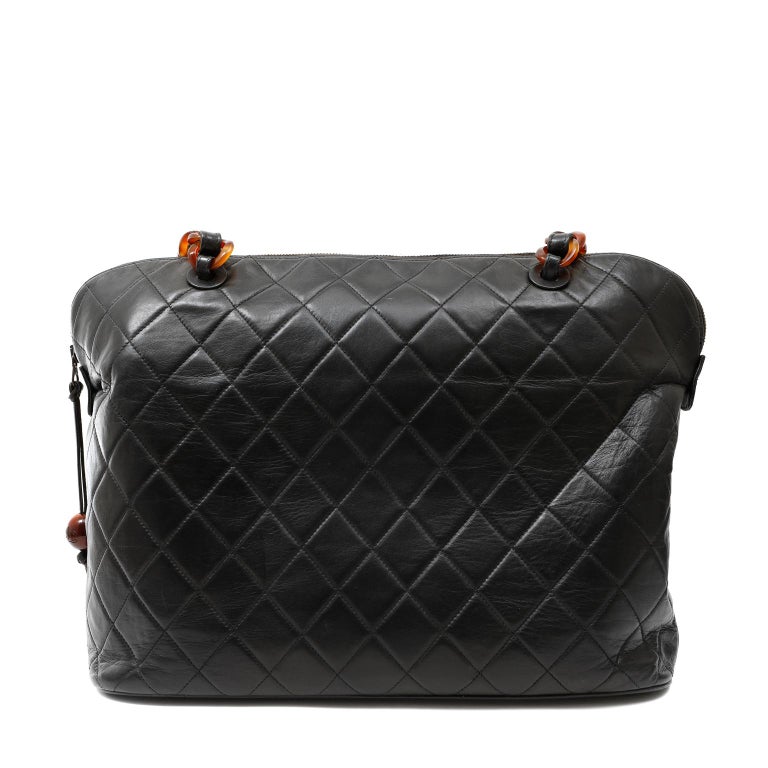 This authentic Chanel Black Leather Tortoise Chain Tote is in excellent vintage condition.  A beautiful piece for any collection that is certain to be enjoyed year-round.
Black leather roomy tote is quilted in signature Chanel diamond pattern. 