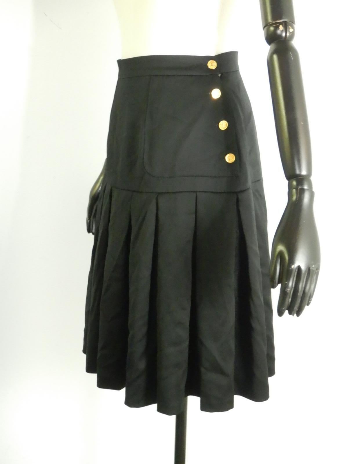 Chanel smooth-finish pleated black wool skirt with 8 gold tone CC logo buttons and side zip closure. Logo-printed silk lining.

The skirt is tagged size 40. The measurements are shown in the photos.

The skirt is in good vintage condition with no
