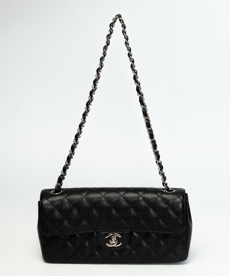 This shoulder bag is made in a luxuriously textured diamond quilted black caviar leather. This extra-wide bag features silver toned hardware, a front flap with the signature interlocking CC turn lock closure, and a gold toned chain interlaced with