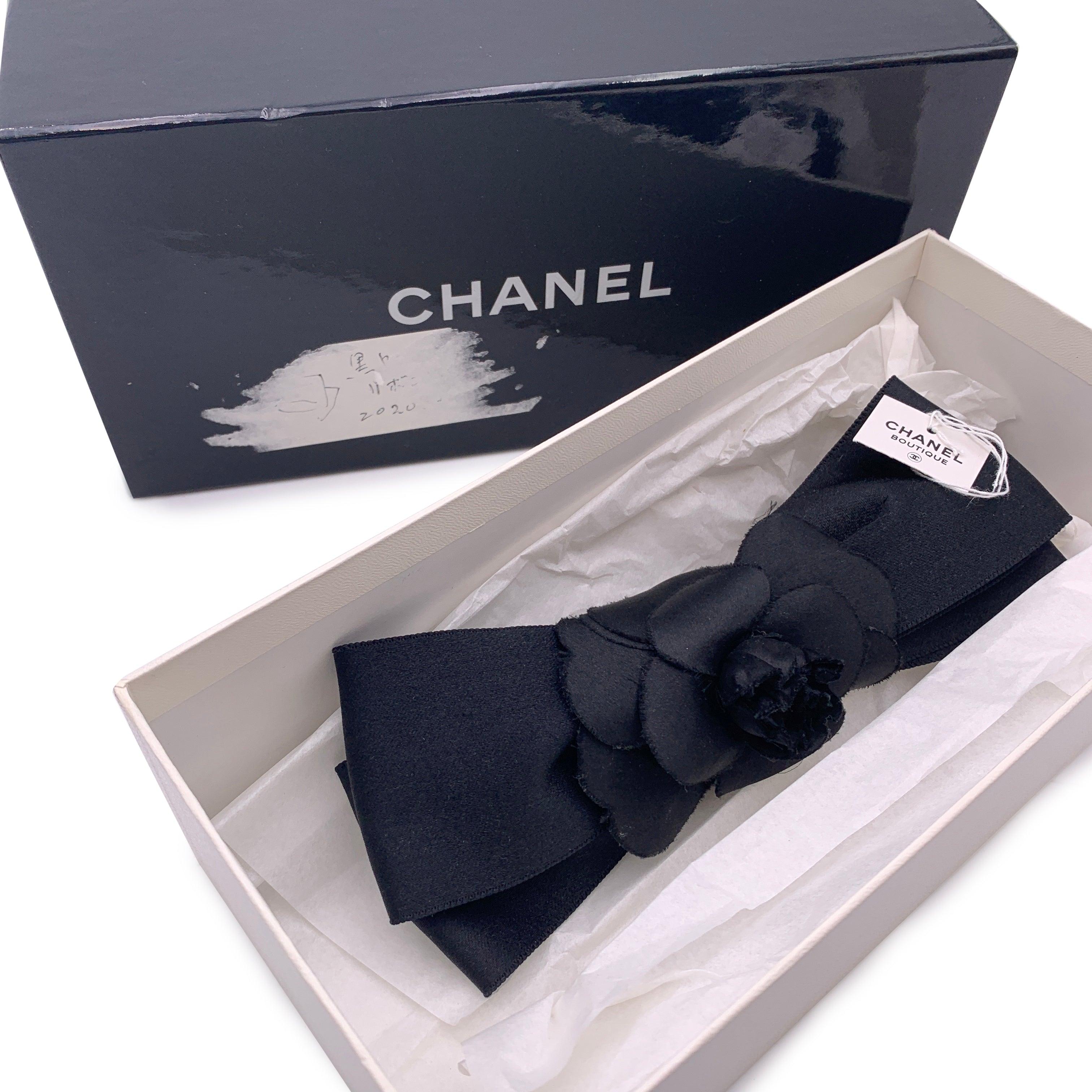 Hübsche Vintage Chanel Haarspange. Schwarze Kamelienblüte aus Satin mit schwarzer Satinschleife. Auf der Rückseite des Clips ist 