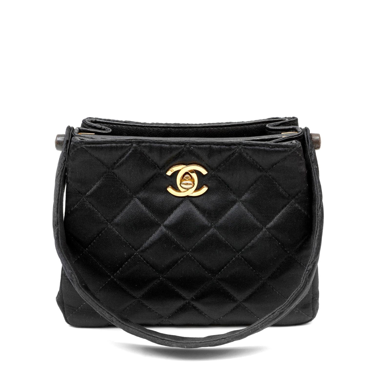 This authentic Chanel Black Satin Double Sided Evening Bag is in beautiful vintage condition.  Rare and collectible, this unique piece features shiny black quilted satin and gold interlocking CC hardware.  Single top handle carry. Dust bag