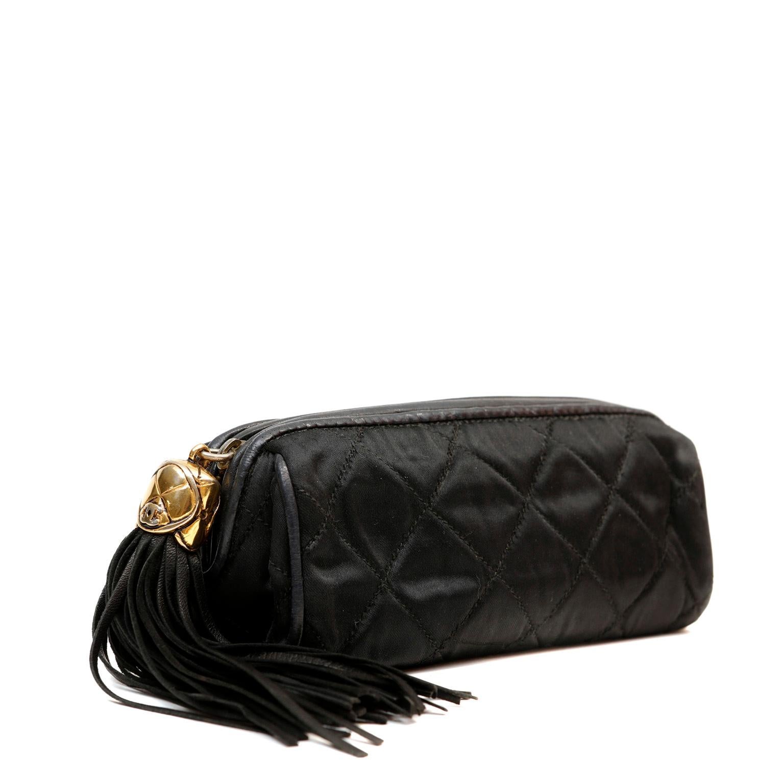 This authentic Chanel Black Satin Tasseled Pouch is in excellent vintage condition.  Beautiful and classic 80’s style cosmetic pouch in quilted black satin with oversized black leather tassel zipper pull. 

PBF 13246