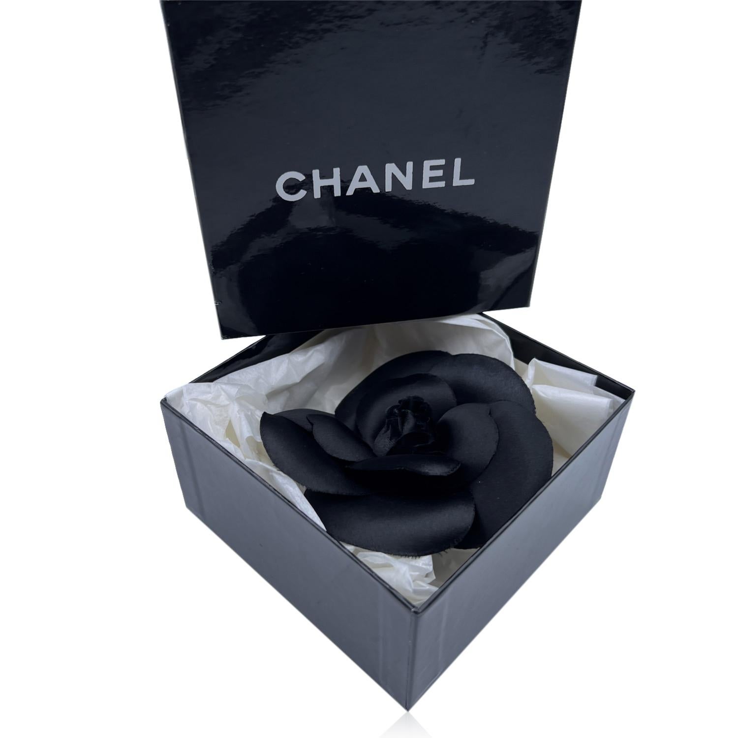 Chanel Vintage Camelia Camellia Flower Pin Brooch. Black satin silk petals. Safety pin closure. Measurements: diameter: 3.5 inches - 8.9 cm. 'CHANEL - CC - Made in France' oval tab on the back

Condition

A - EXCELLENT

Gently used. Chanel box