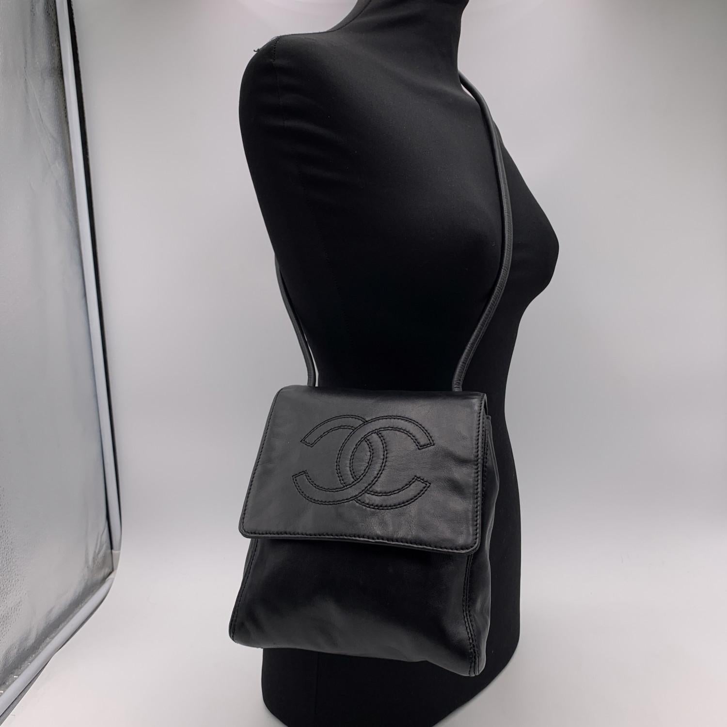 Vintage Chanel black smooth leather shoulder bag. CC - CHANEL logo stitched on the flap. Period/Era: 1997 -1999. It features a front flap with magnetic button closure and a rear open pocket. Black canvas lining with double zip closure. 'CHANEL -