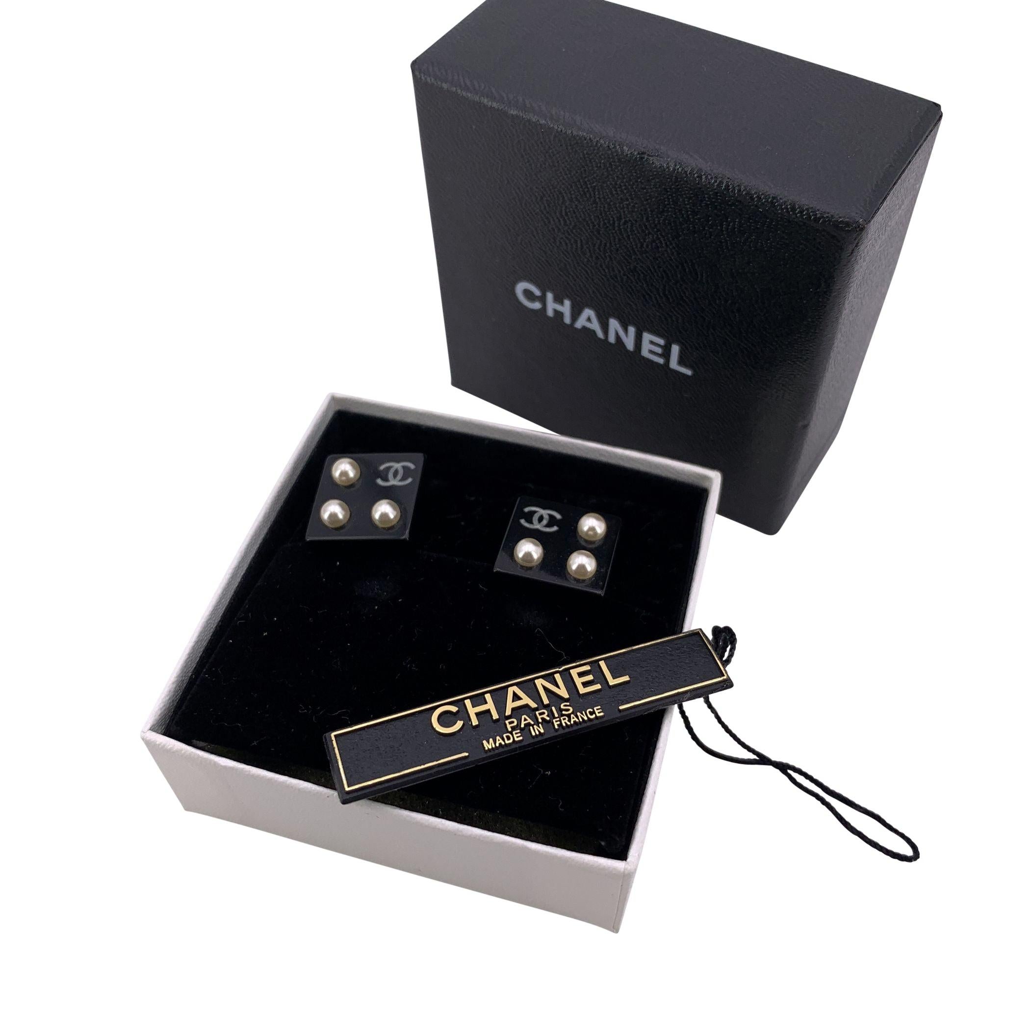 These elegant pre-owned Chanel earrings date back to around 2003, created under the creative direction of Karl Lagerfeld. Beautifully crafted in black resin, each square-shaped earring features 3 faux pearls arranged symmetrically around Chanel's