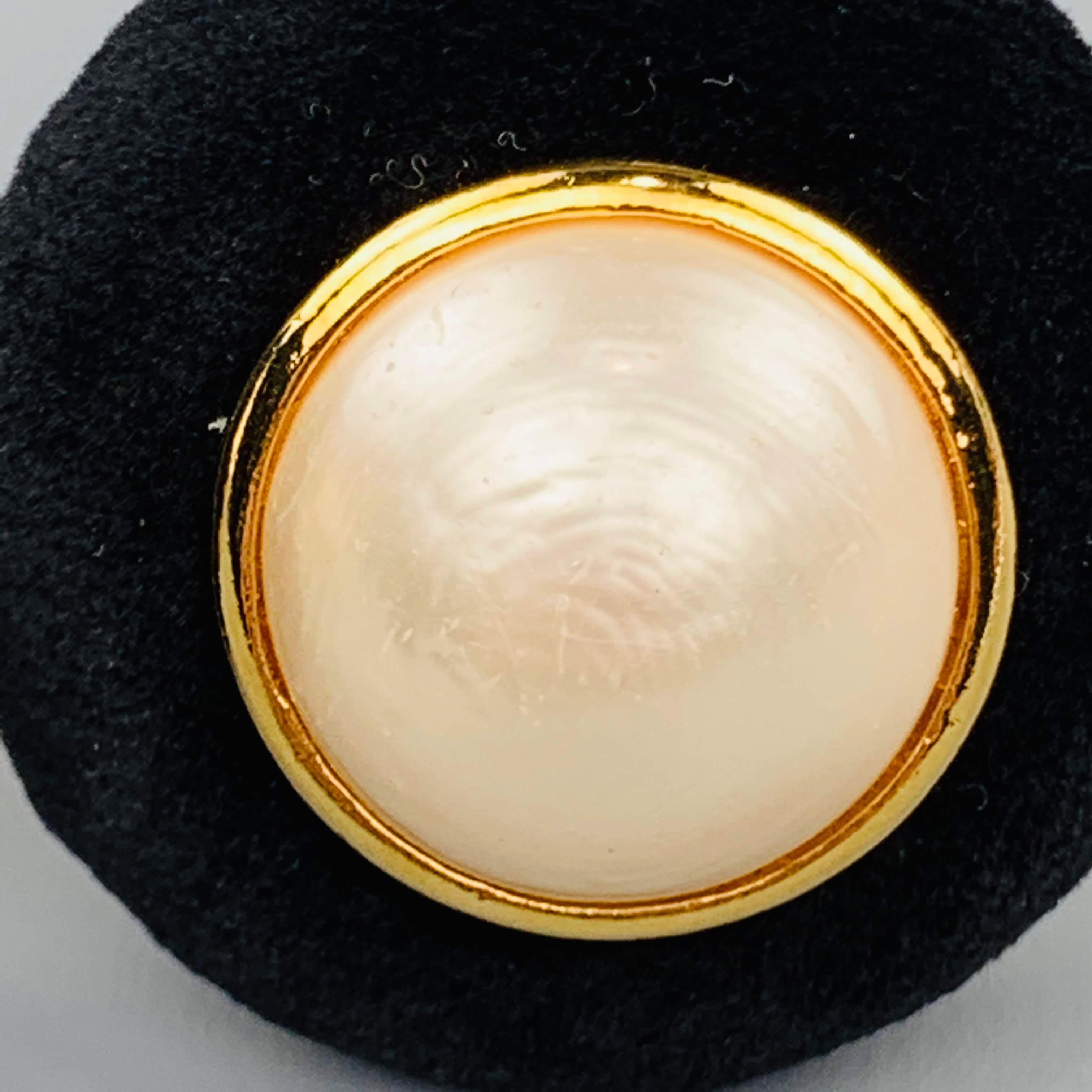 Vintage Season 23 circa 1986 circular clip on earrings comes in yellow gold tone metal with black velvet front and faux pearl motif. Made in France.
 
Very Good Pre-Owned Condition.
Marked: 23
 
4 x 4 cm.