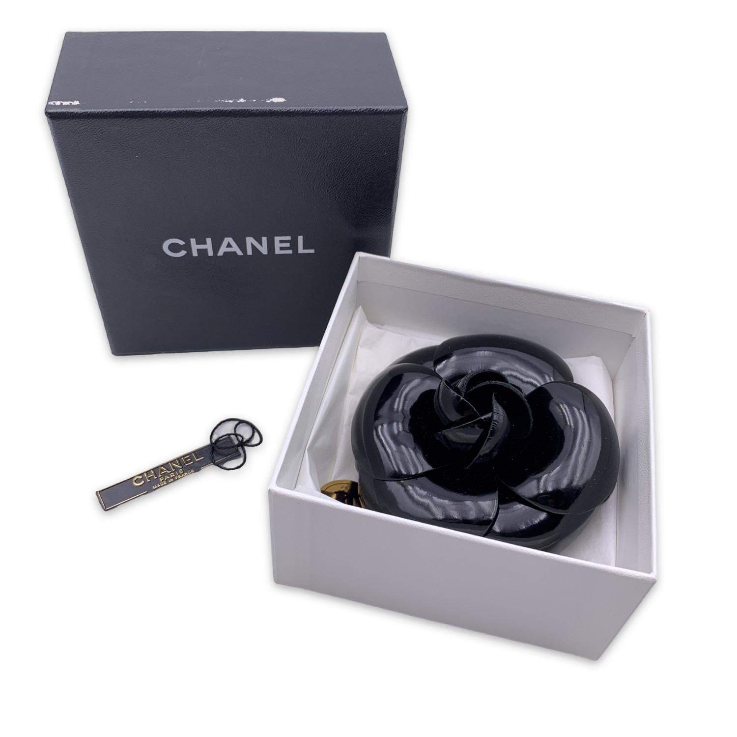 Chanel Vintage Camelia Camellia Flower Pin Brooch. Black vinyl petals. Safety pin closure. Measurements: diameter: 4 inches - 10.2 cm. 'CHANEL - CC - Made in France' oval tab on the back

Condition

A - EXCELLENT

Gently used. Minimal wear of use on