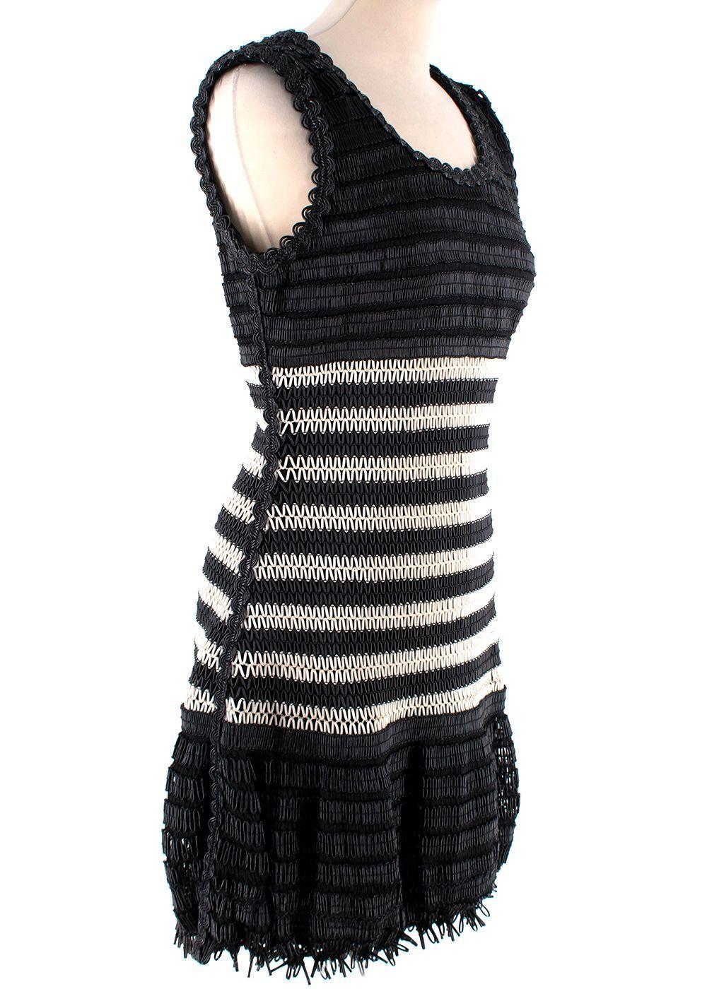 Chanel Vintage Black & White Woven Mini Dress

- Incredible vintage piece from Spring '94
- Woven from black and white vinyl tubing in a chevron-like pattern
- Drop waist, with a textured, 3-D hemline 
- Scoop neck, sleeveless 
- Fully lined