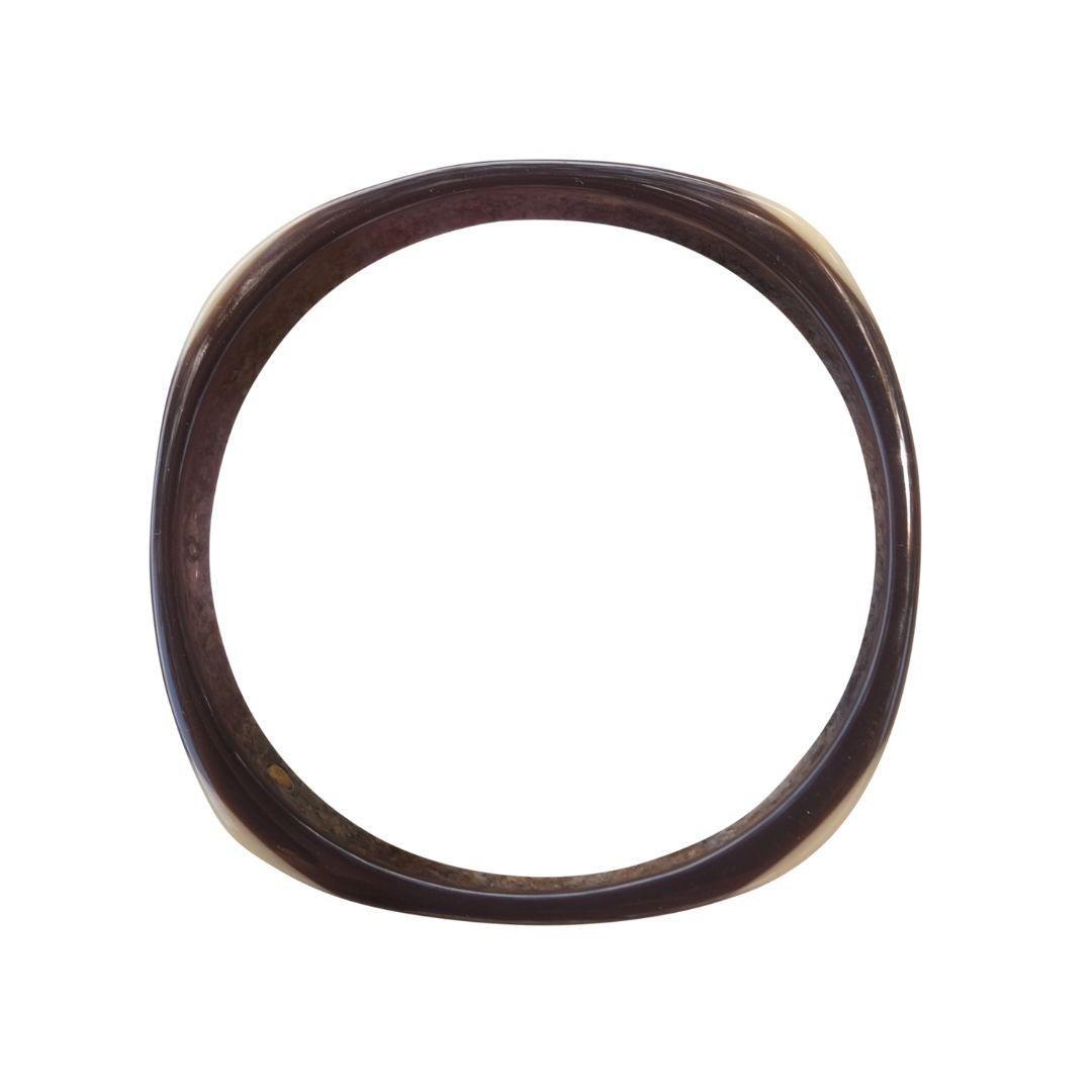 Vintage Chanel brown and beige acrylic bangle from the fall 2001 Collection by Karl Lagerfeld.

The bracelet is circular with subtle, softly squared corners.

CC interlock logo on two opposite sides.

Condition Details: In very good, vintage