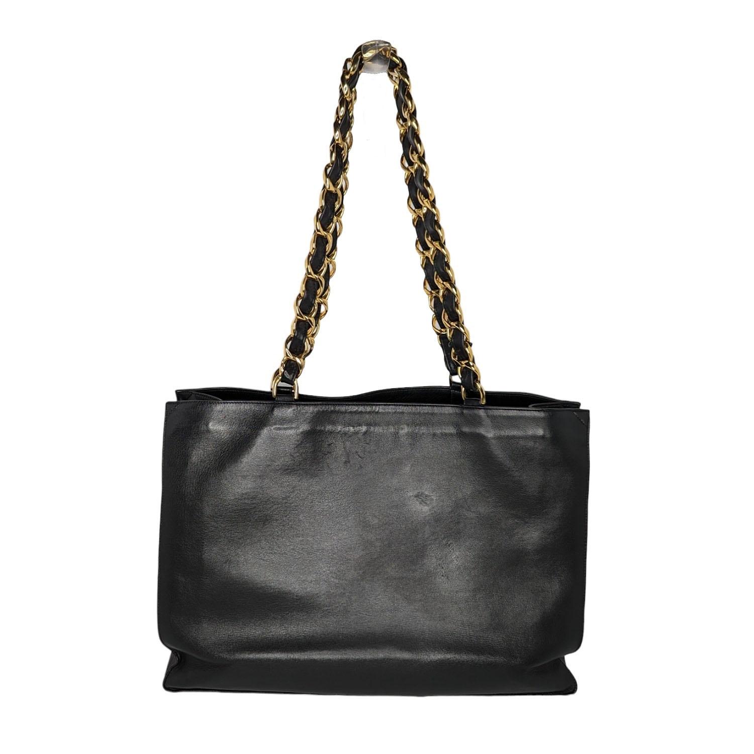 Chanel Vintage CC Chain Shopper Tote. This stunning tote, circa 90s, is crafted of luxuriously smooth Calfskin leather in black. The bag features a large, stitched CC quilted logo and leather threaded chain link straps. The top opens to a black