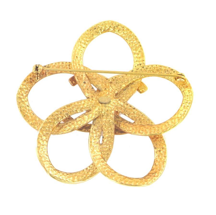 CHANEL vintage camellia brooch. in the center, the acronym 'CC'. It is brass gilded with fine gold.

Dimensions : Diameter of the flower: 6.7cm, Circumference of the flower: 21cm, Dimensions of the 'CC': 3 x 2.5cm

Will be delivered in its CHANEL