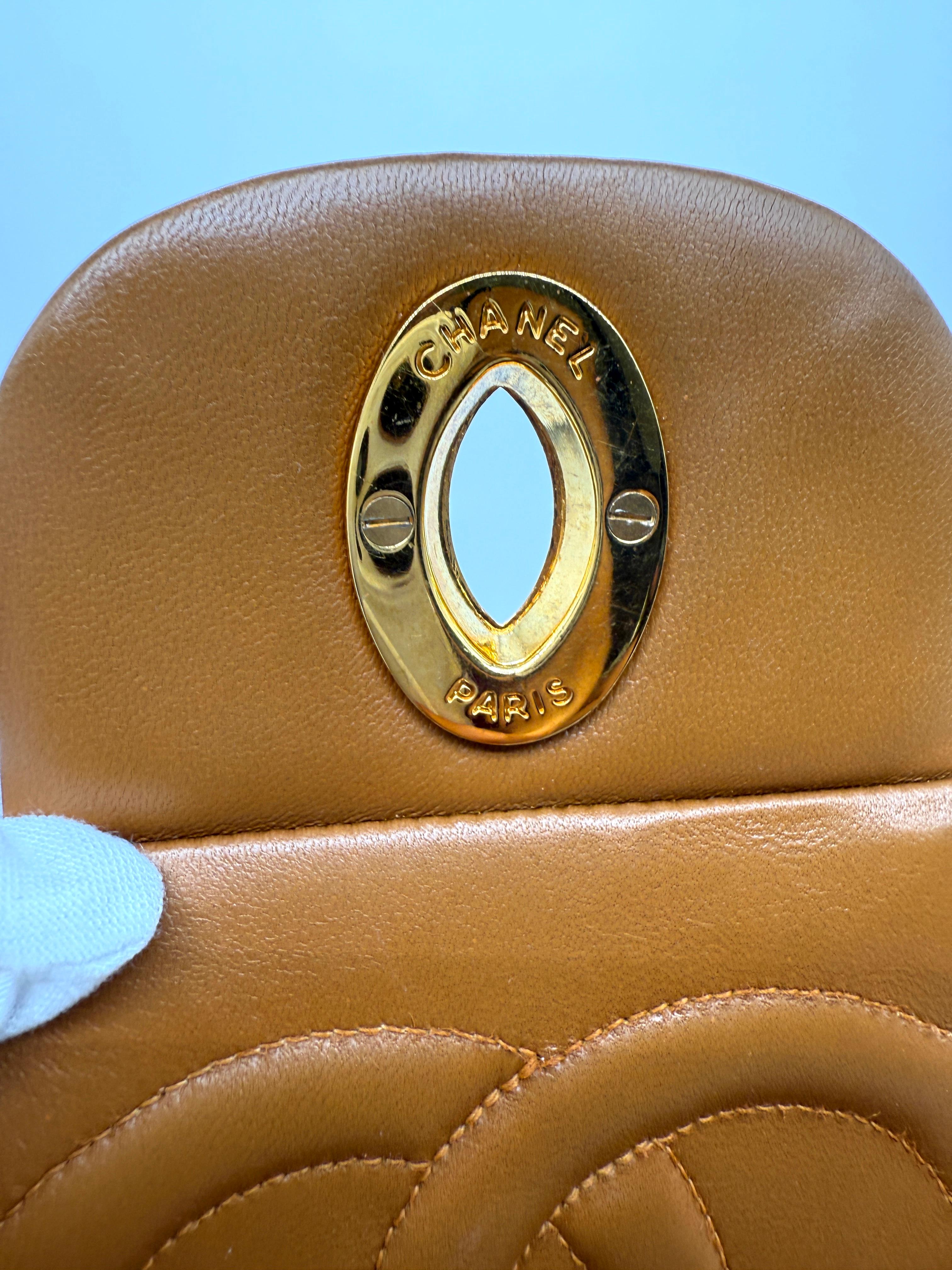 This stunning Chanel Vintage Carmel Maxi Lambskin Flap Bag is from Series 2 (1991–1994), crafted in rich, buttery caramel lambskin and adorned with 24k gold-plated hardware. 

Measuring approximately 34 cm × 23 cm × 10 cm (13.4″ × 9.1″ × 3.9″), it’s