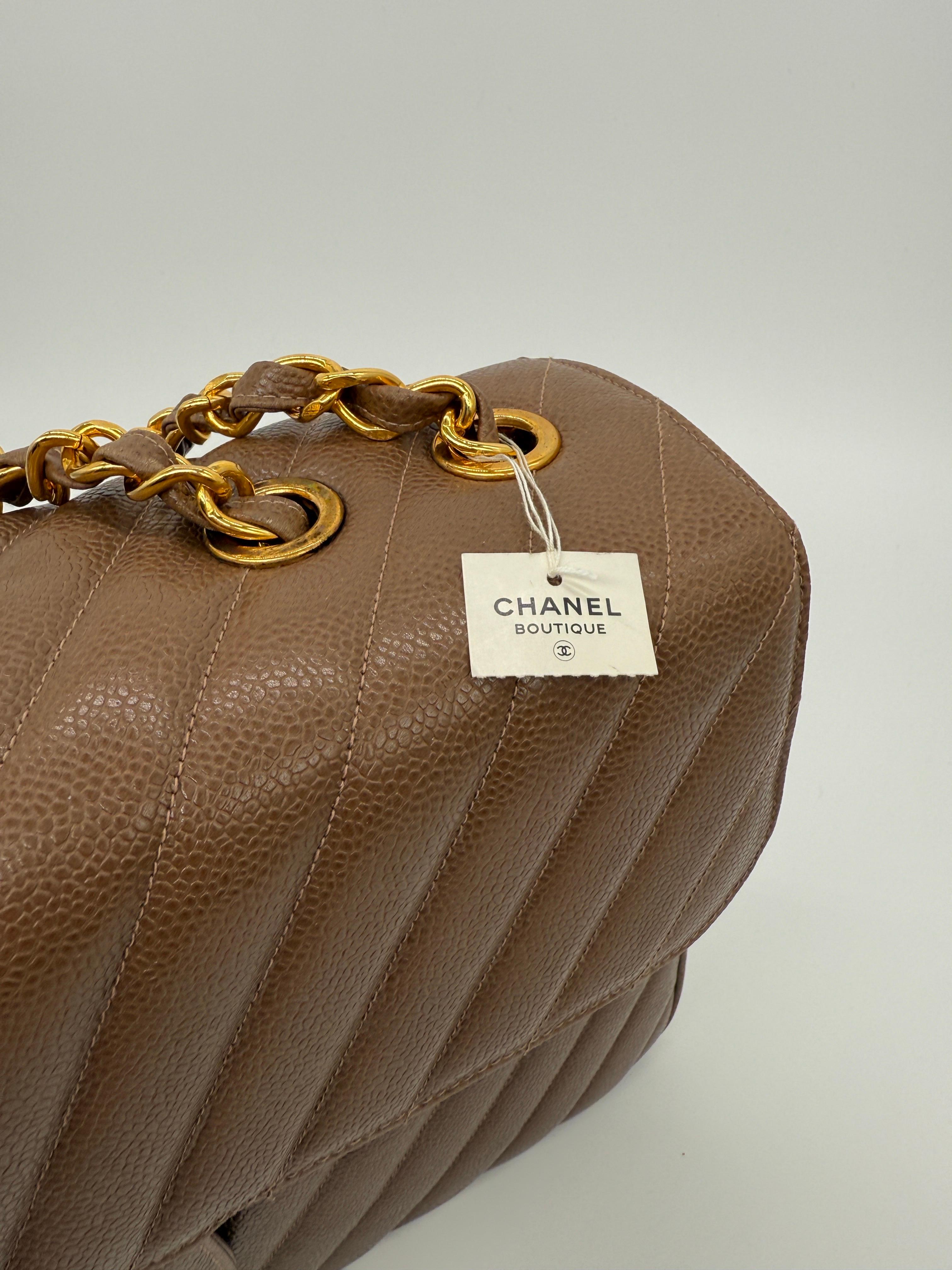 An extraordinary collector’s piece, this vintage Chanel Classic Maxi Flap is crafted in durable chestnut brown caviar leather and finished with 24k gold-plated hardware. It remains completely unworn, still retaining its original 1990s boutique tag,