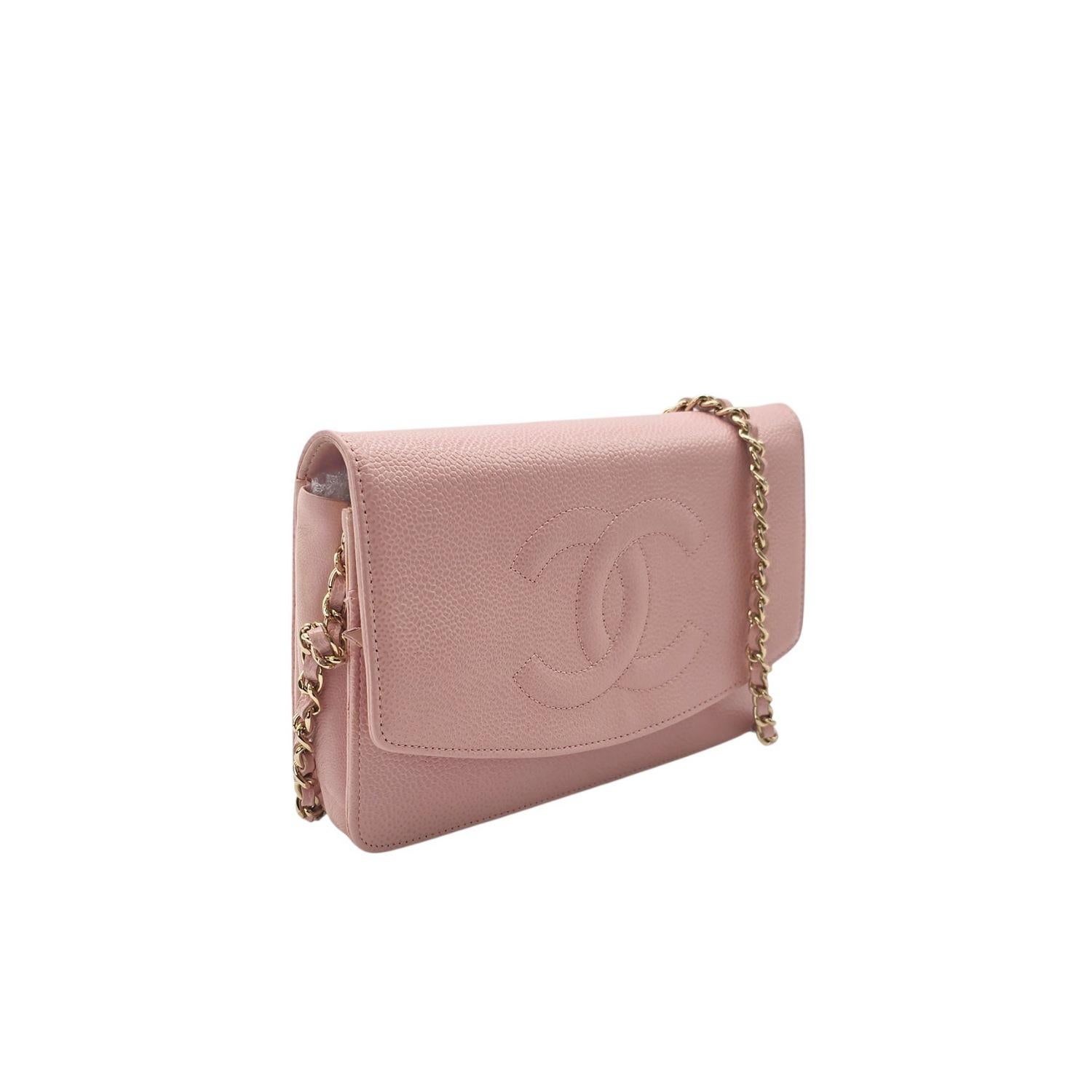 This stylish wallet is crafted of luxuriously textured caviar leather in pink, with a Chanel CC logo embossed on the front. The bag features a leather threaded gold-tone chain-link shoulder strap and a crossover flap. This opens to a beige fabric