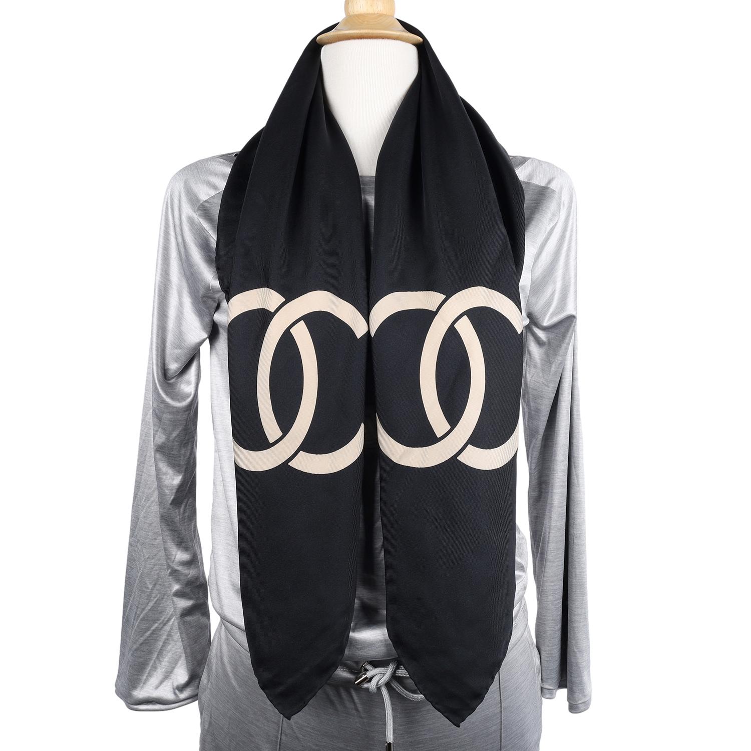 Authentique écharpe en soie Chanel CC Logo en beige et noir. Rare, indispensable. Très belle ! 
Cette écharpe en soie, d'une élégance sans effort, vous enveloppe littéralement d'une couverture de douceur délicate. Le motif emblématique a été