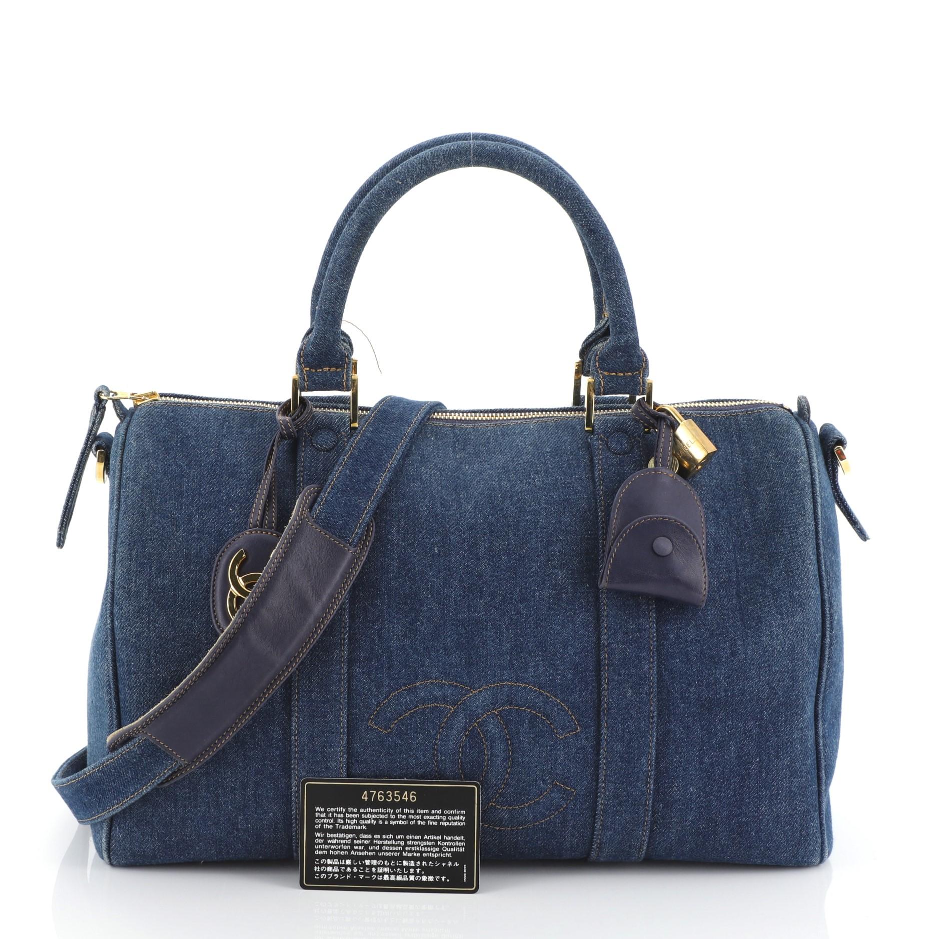 This Chanel Vintage CC Boston Bag Denim Medium, crafted in blue denim, features dual rolled leather handles and gold-tone hardware. Its zip closure opens to a black fabric interior with zip pocket. Hologram sticker reads: 4763546. 

Condition: Very
