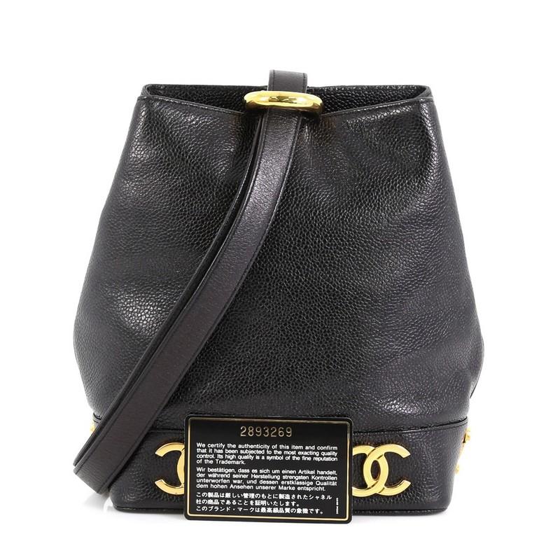 This Chanel Vintage CC Bucket Shoulder Bag Caviar Mini, crafted in black caviar leather, features leather shoulder strap, metal CC logos at the base, and gold-tone hardware. It opens to a black leather interior with zip pocket. Hologram sticker