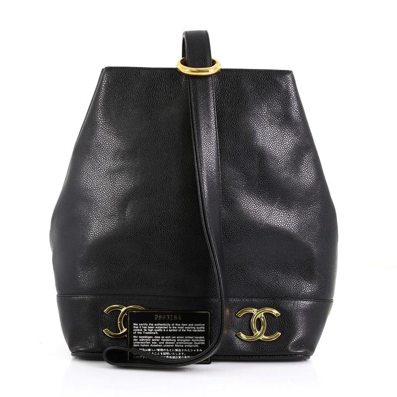 This Chanel Vintage CC Bucket Shoulder Bag Caviar Small, crafted in black caviar leather, features leather shoulder strap, metal CC logos at the base, and gold-tone hardware. It opens to a black leather interior with zip pocket. Hologram sticker