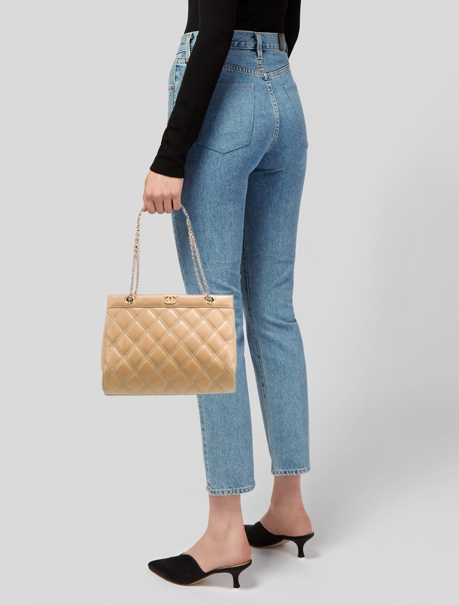 Este bolso bandolera Chanel de la colección 2000-2002 de Karl Lagerfeld está fabricado en piel de caviar beige con una silueta estructurada enmarcada. Presenta herrajes dorados, tirantes de eslabones de cadena y dos bolsillos exteriores. El bolso se