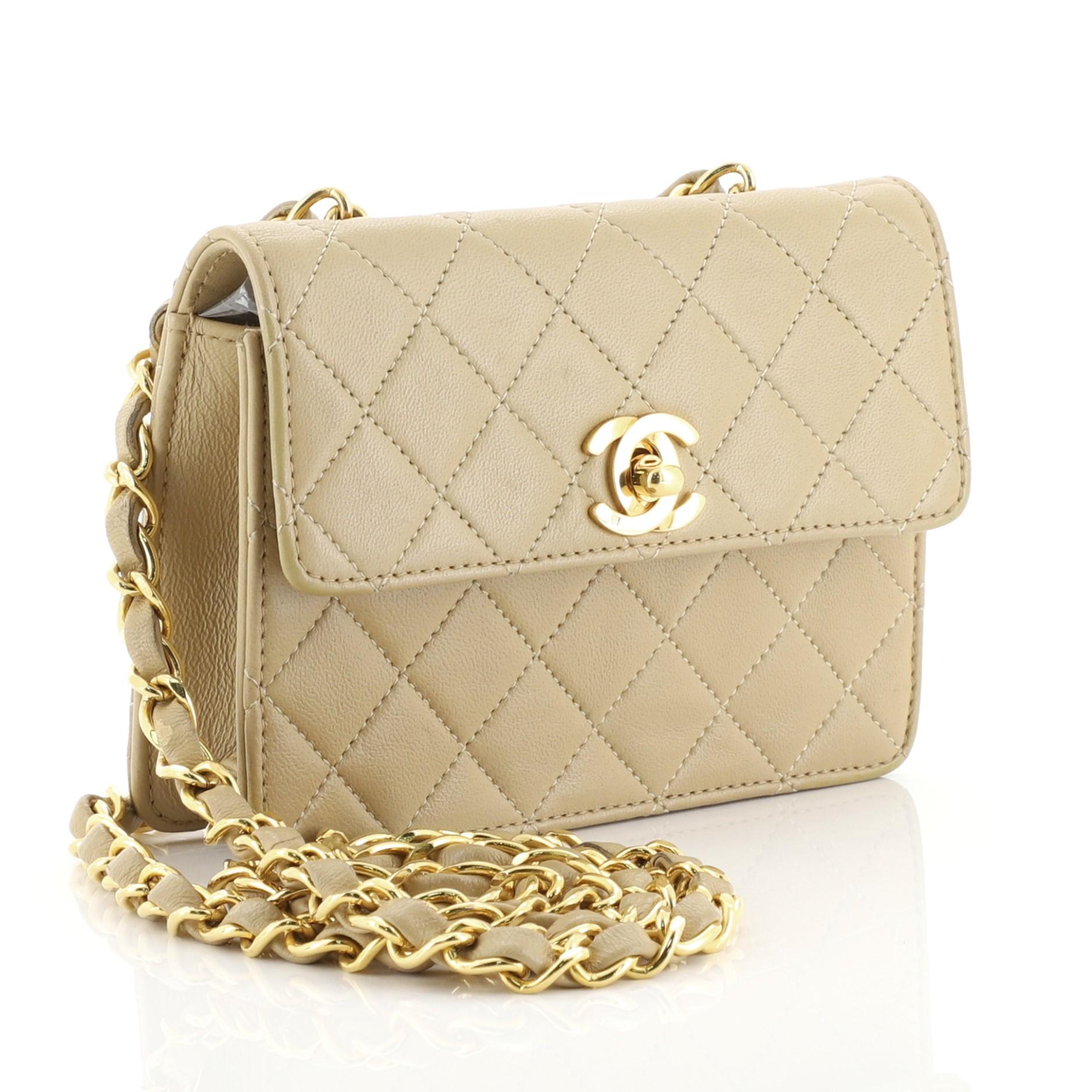 This Chanel Vintage CC Chain Flap Bag Quilted Leather Extra Mini, crafted from neutral quilted leather, features woven-in leather chain link strap and gold-tone hardware. Its CC turn-lock closure opens to a neutral leather interior. Hologram sticker