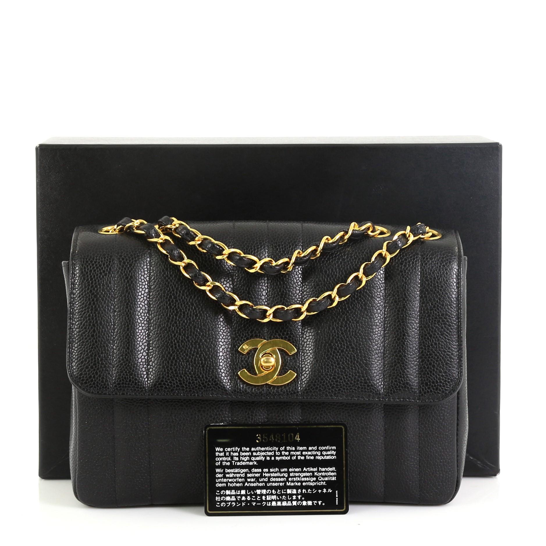 This Chanel Vintage CC Chain Flap Bag Vertical Quilt Caviar Small, crafted in black caviar leather, features woven-in gold leather chain link shoulder strap, signature gold-tone CC turn-lock closure and gold-tone hardware. Its turn-lock closure